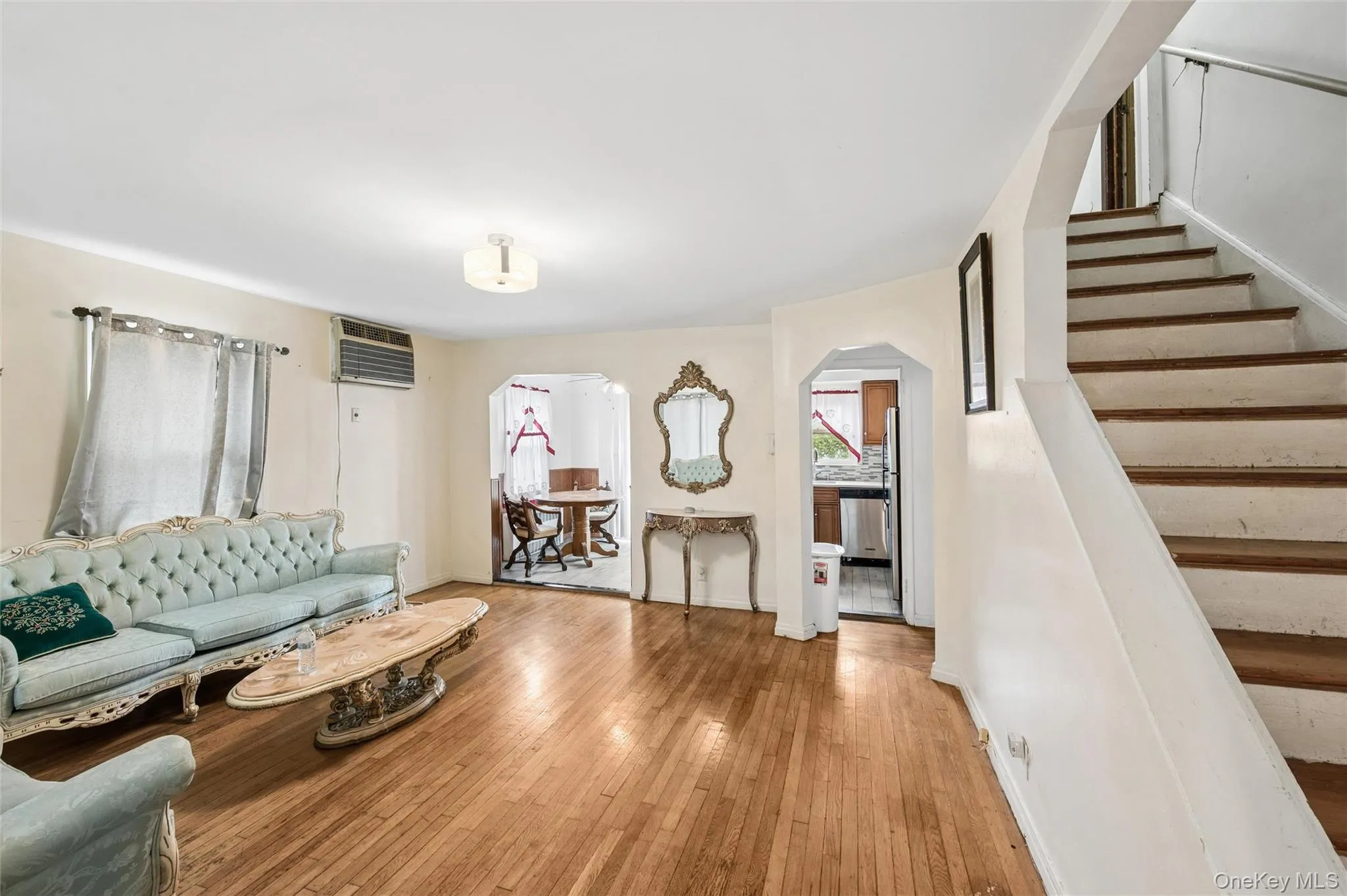 Living room featuring wood-finish flooring and a ceiling-mounted light fixture Living room featuring wood-finish flooring and a ceiling-mounted light fixture