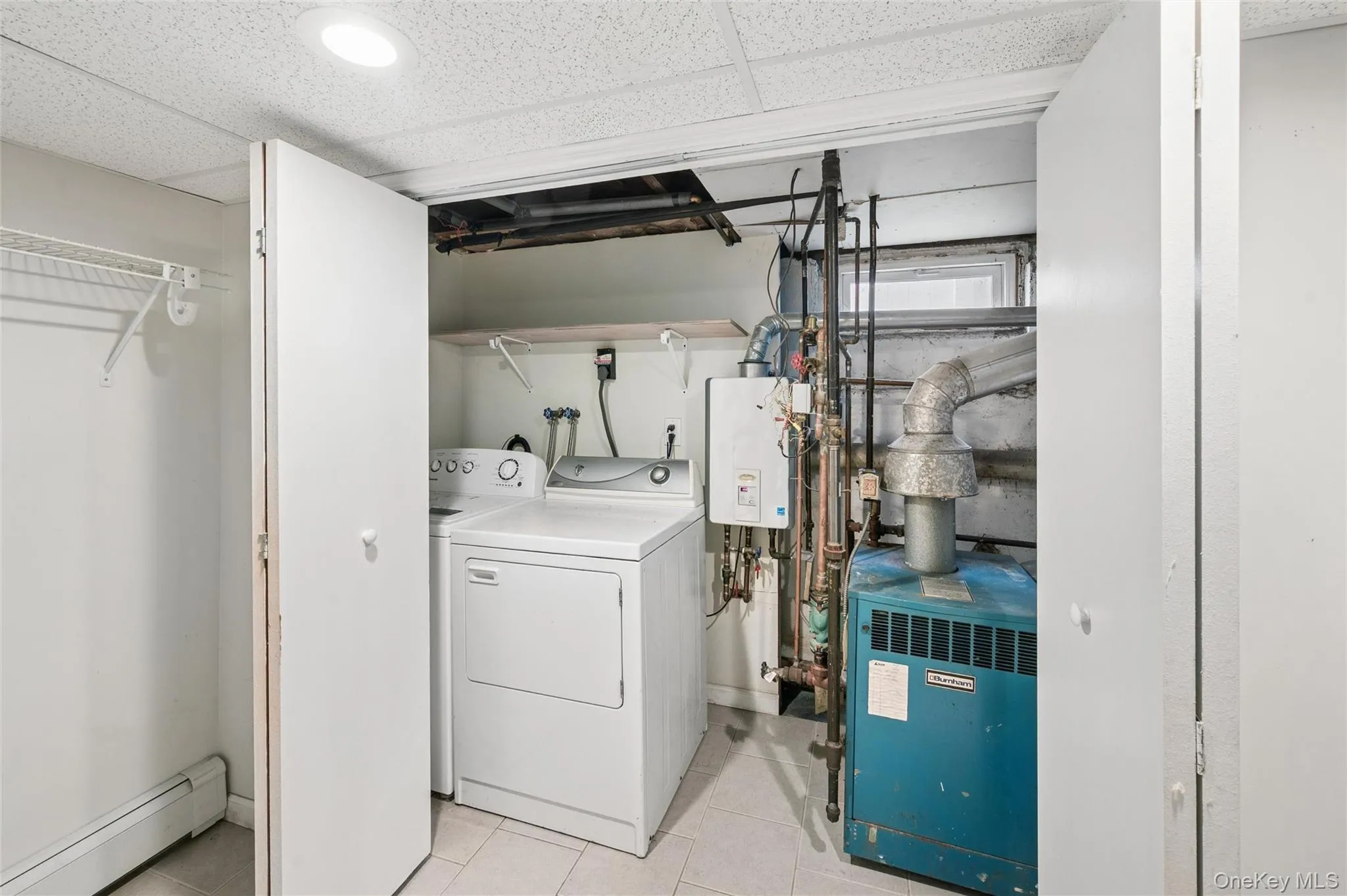 Dedicated utility area featuring a washer and dryer, tiled flooring, and recessed lighting Dedicated utility area featuring a washer and dryer, tiled flooring, and recessed lighting