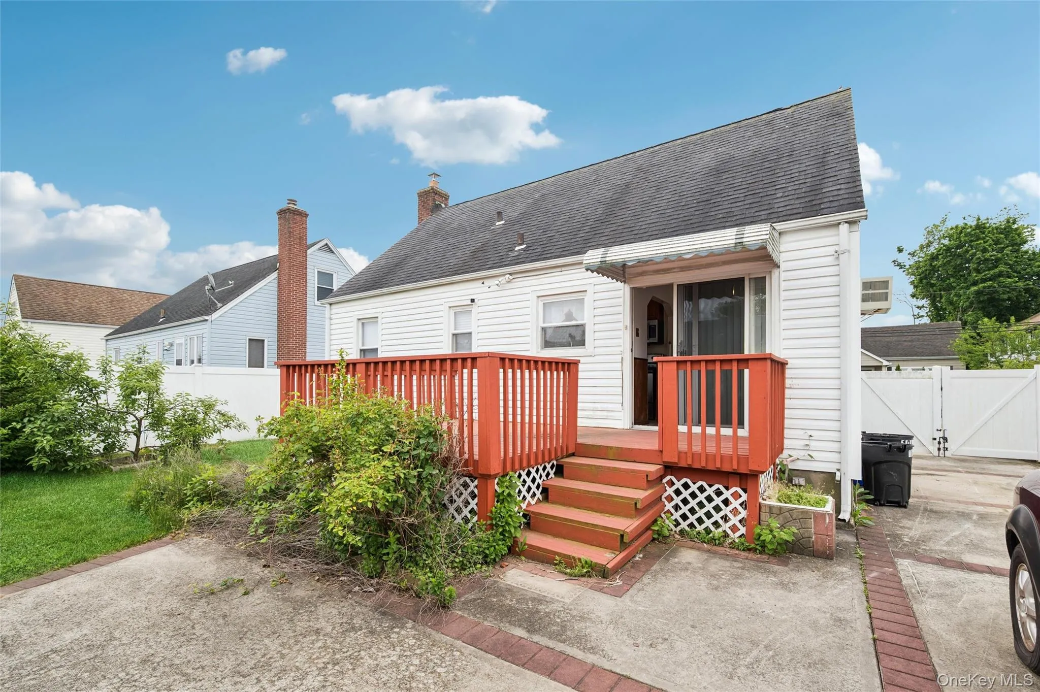 Rear exterior featuring white vinyl siding and a dark shingled roof Rear exterior featuring white vinyl siding and a dark shingled roof