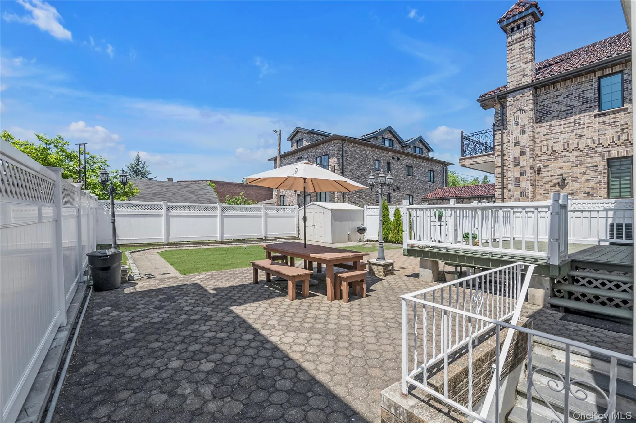 Backyard spacious wooden deck and brick patio , full sized shed at the corner Backyard spacious wooden deck and brick patio , full sized shed at the corner