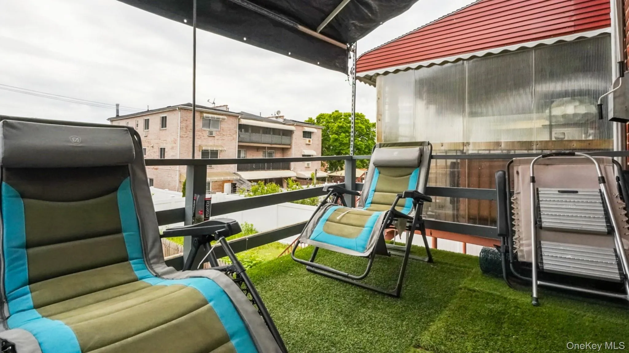 Outdoor balcony featuring artificial turf flooring and a black metal railing Outdoor balcony featuring artificial turf flooring and a black metal railing