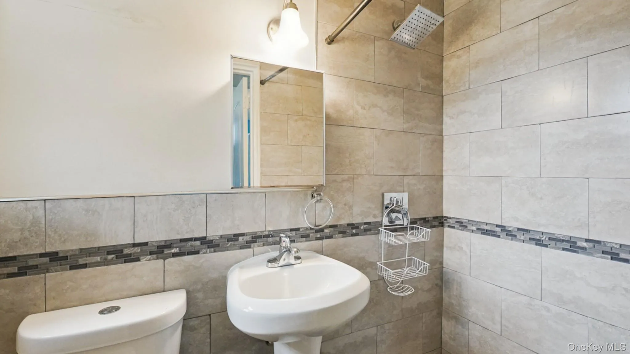 Bathroom featuring full-height tiled walls, a decorative mosaic tile accent band, and a rainfall showerhead Bathroom featuring full-height tiled walls, a decorative mosaic tile accent band, and a rainfall showerhead
