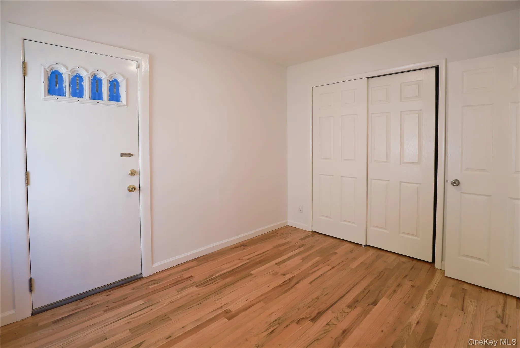 Room featuring natural wood-finish flooring complementing the neutral wall tones Room featuring natural wood-finish flooring complementing the neutral wall tones