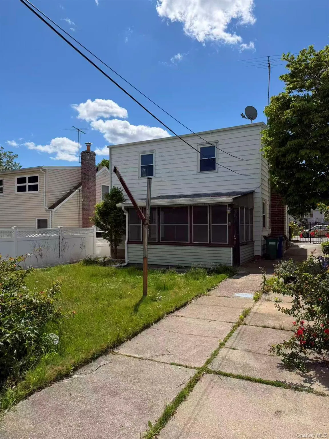 Two-story residential structure with white siding and multiple windows Two-story residential structure with white siding and multiple windows