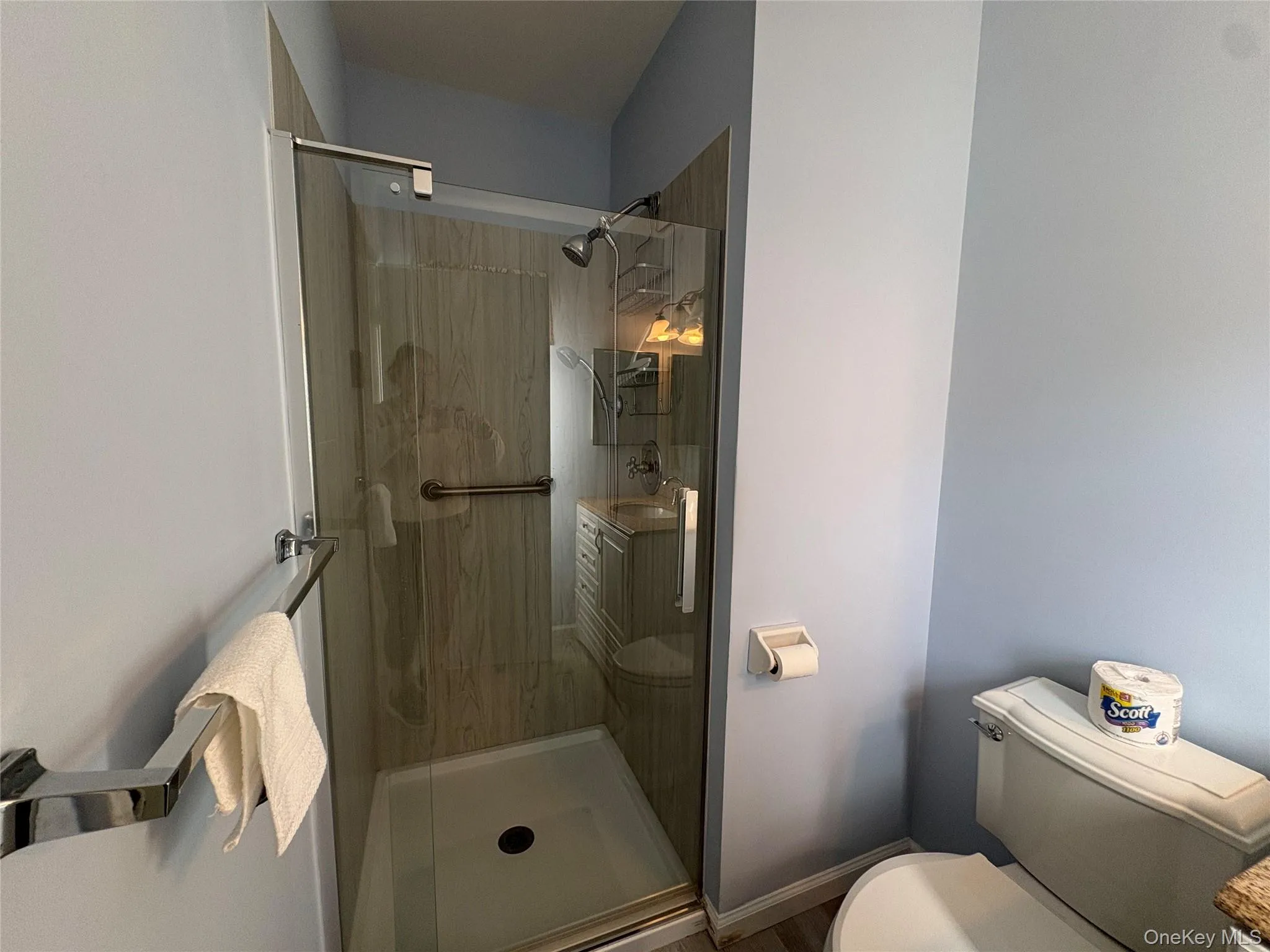 Shower enclosure with clear glass door, chrome hardware, and vertical-patterned shower surround Shower enclosure with clear glass door, chrome hardware, and vertical-patterned shower surround