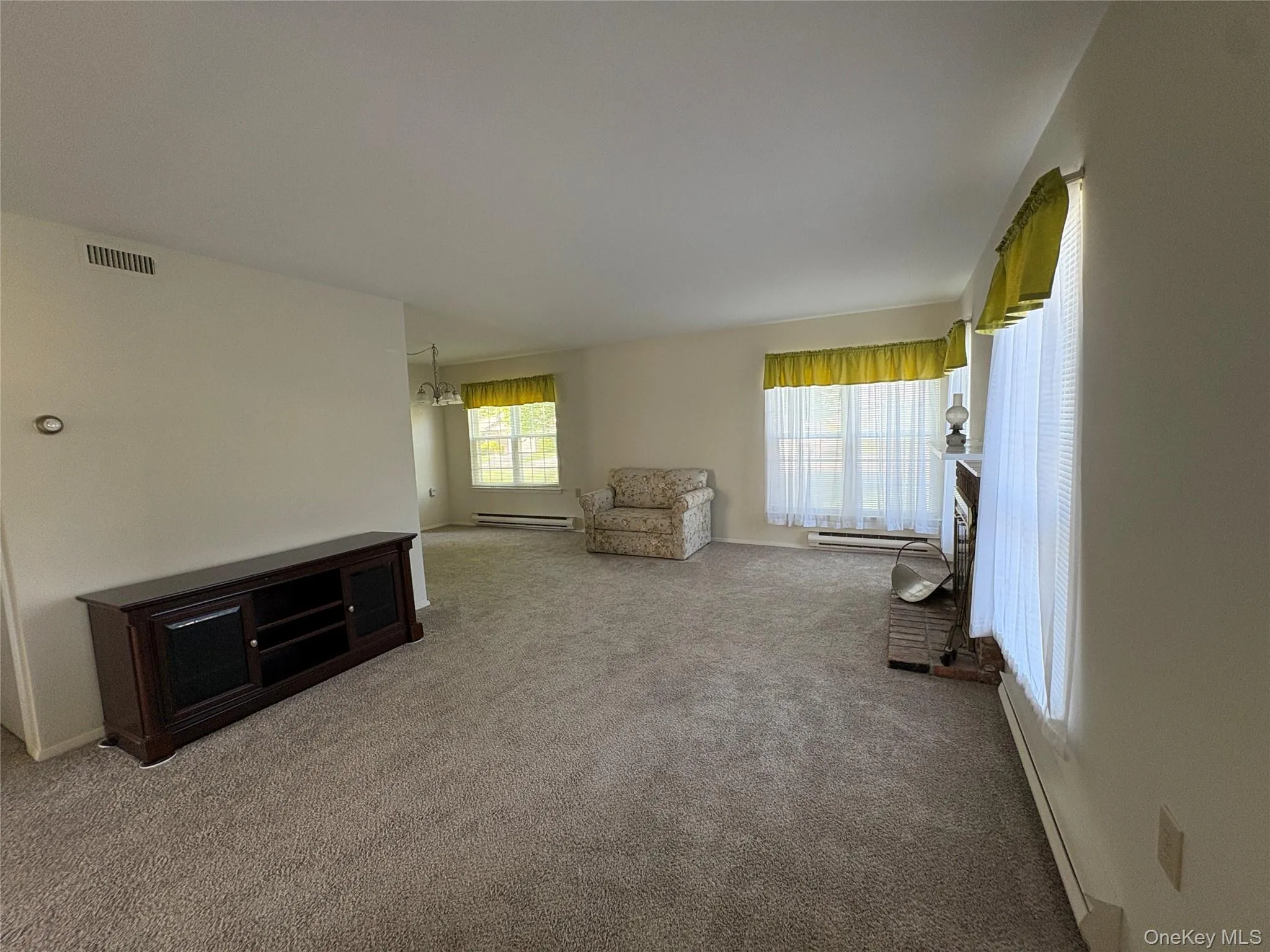 Large open living room with neutral carpeting gives a sense of spaciousness throughout the home. Large open living room with neutral carpeting gives a sense of spaciousness throughout the home.