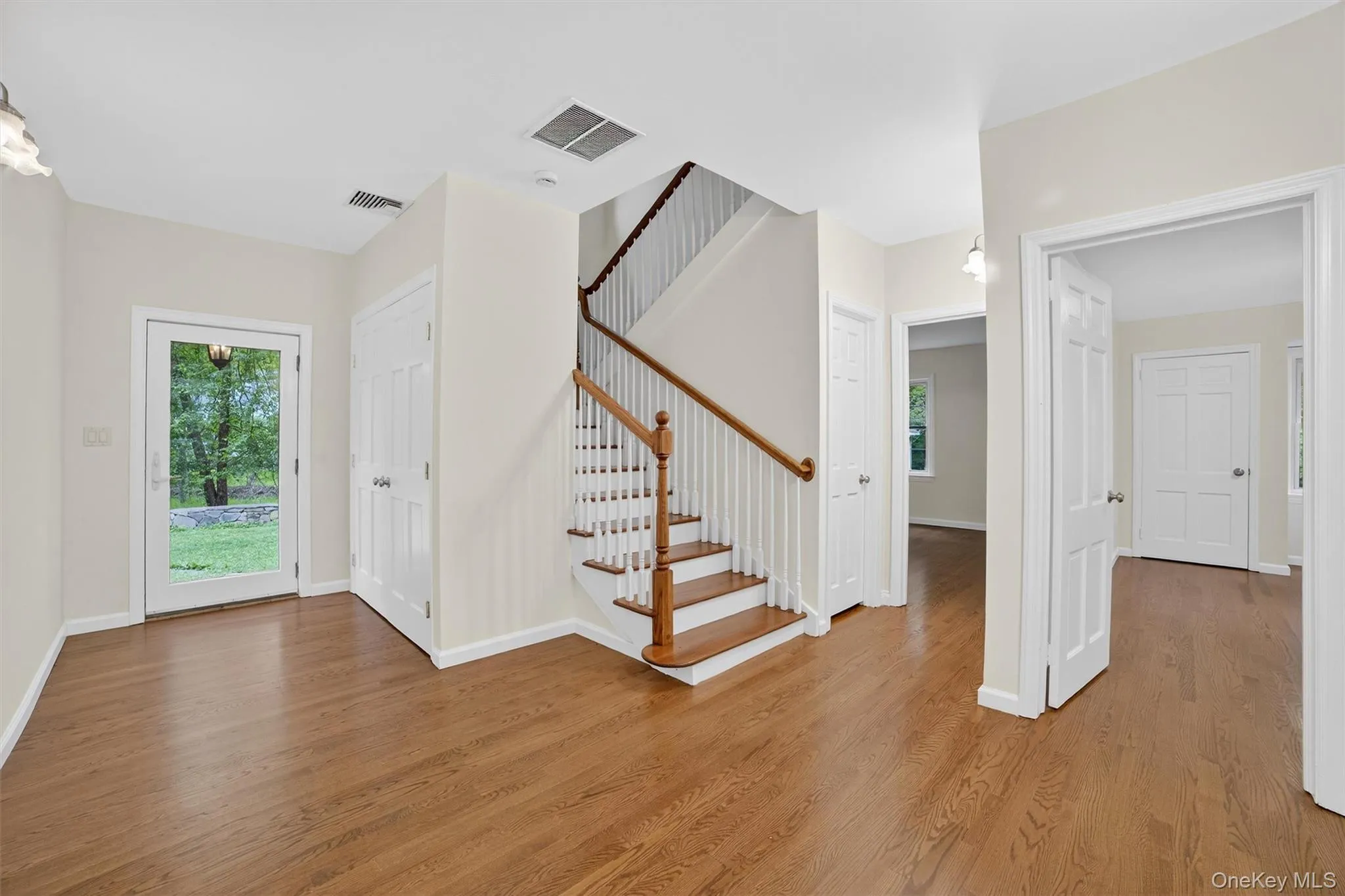 Entrance foyer featuring light wood finished floors and stairway Entrance foyer featuring light wood finished floors and stairway