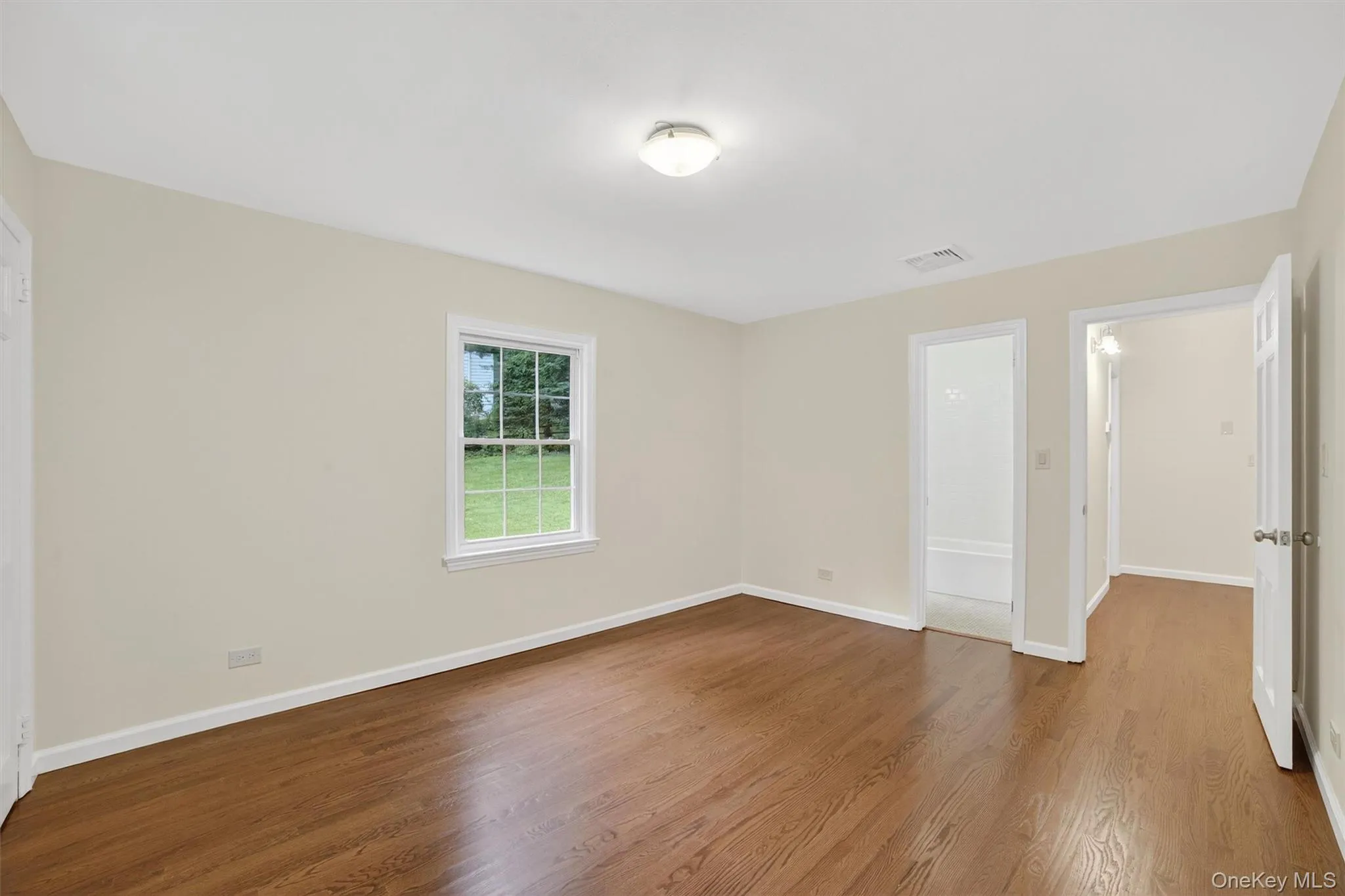 Unfurnished room with wood finished floors and baseboards Unfurnished room with wood finished floors and baseboards