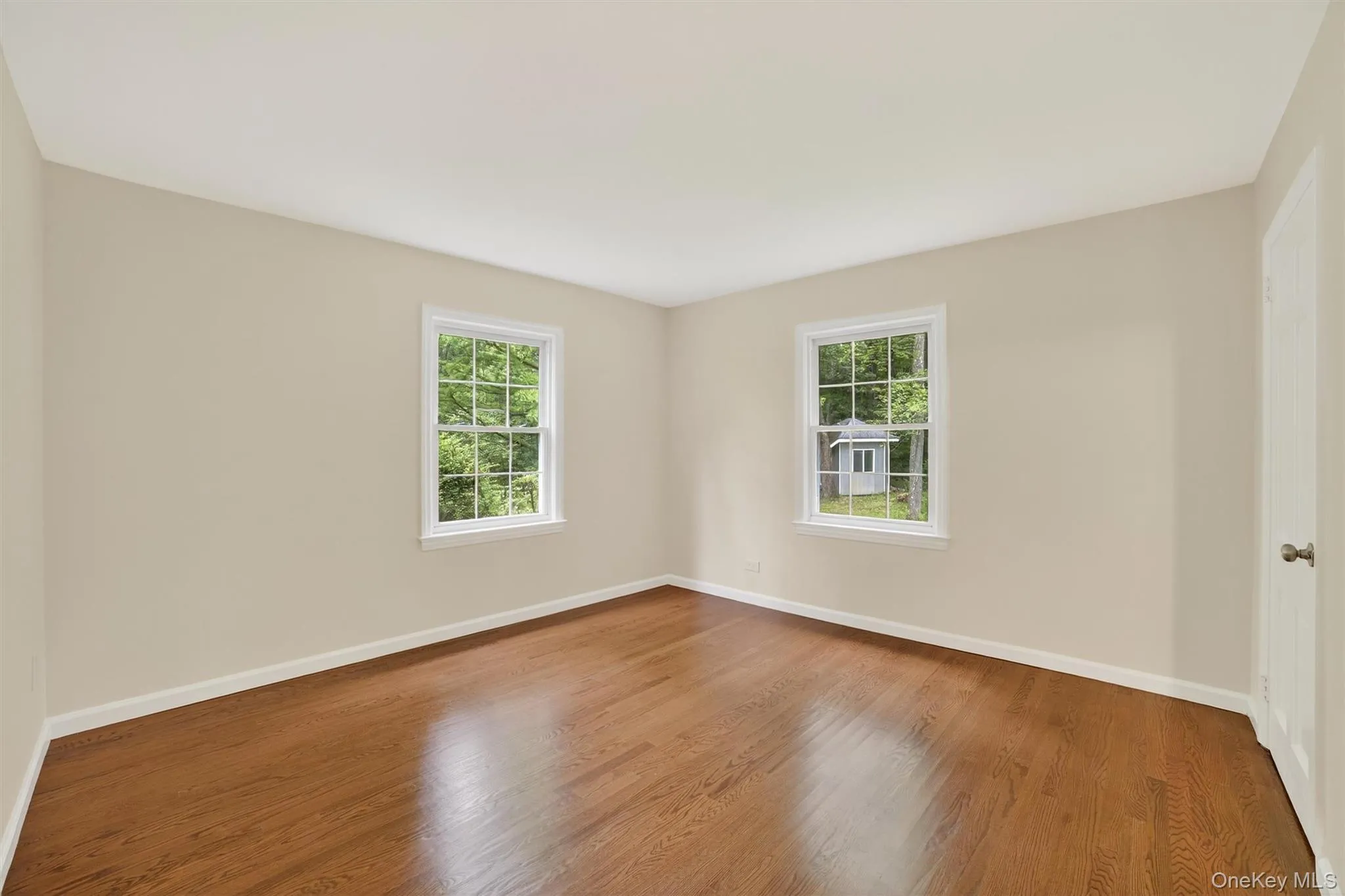 Empty room with plenty of natural light and wood finished floors Empty room with plenty of natural light and wood finished floors
