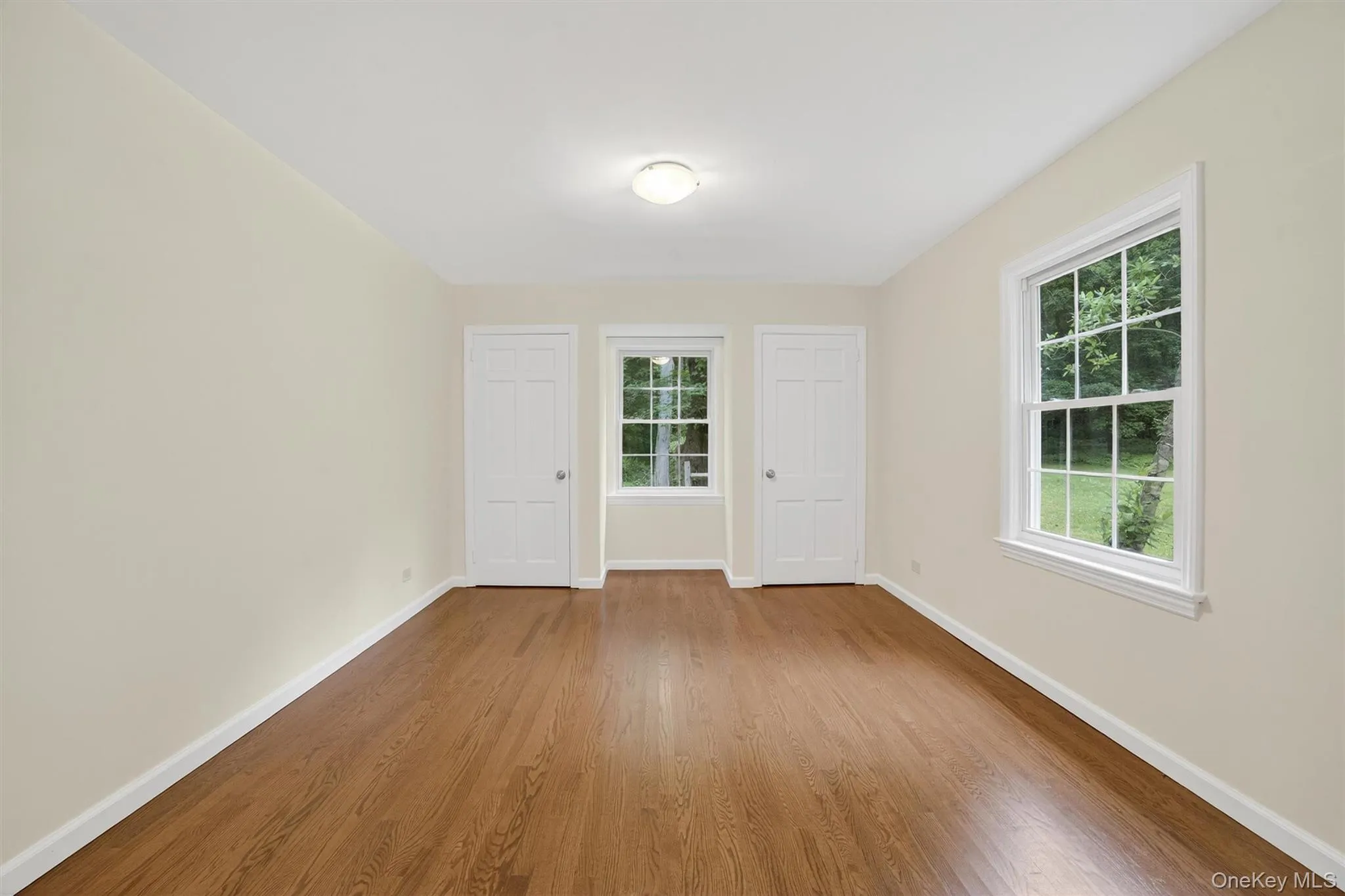 Empty room featuring wood finished floors and baseboards Empty room featuring wood finished floors and baseboards