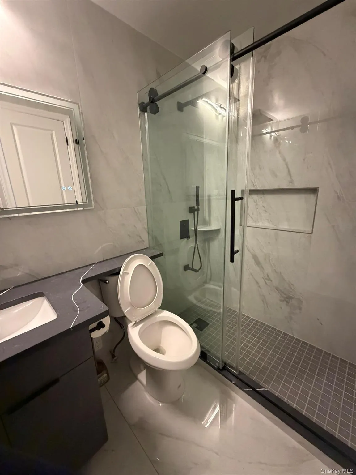 Bathroom with vanity and a marble finish shower Bathroom with vanity and a marble finish shower