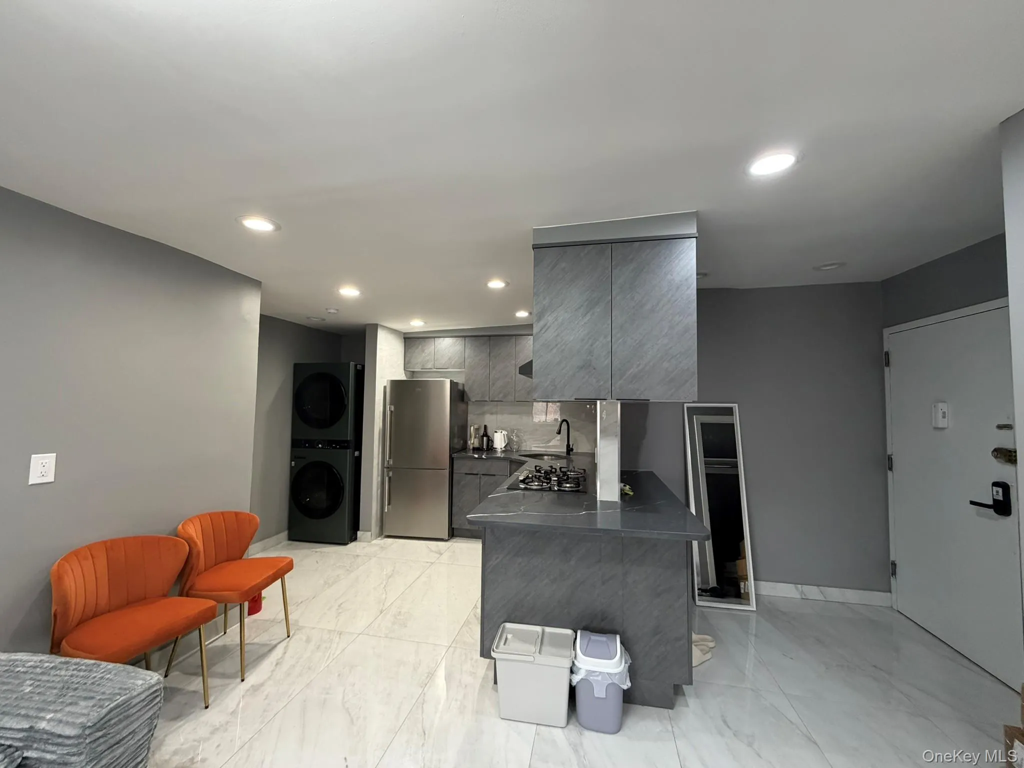 Kitchen with a peninsula, gray cabinets, appliances with stainless steel finishes, recessed lighting, and dark countertops Kitchen with a peninsula, gray cabinets, appliances with stainless steel finishes, recessed lighting, and dark countertops