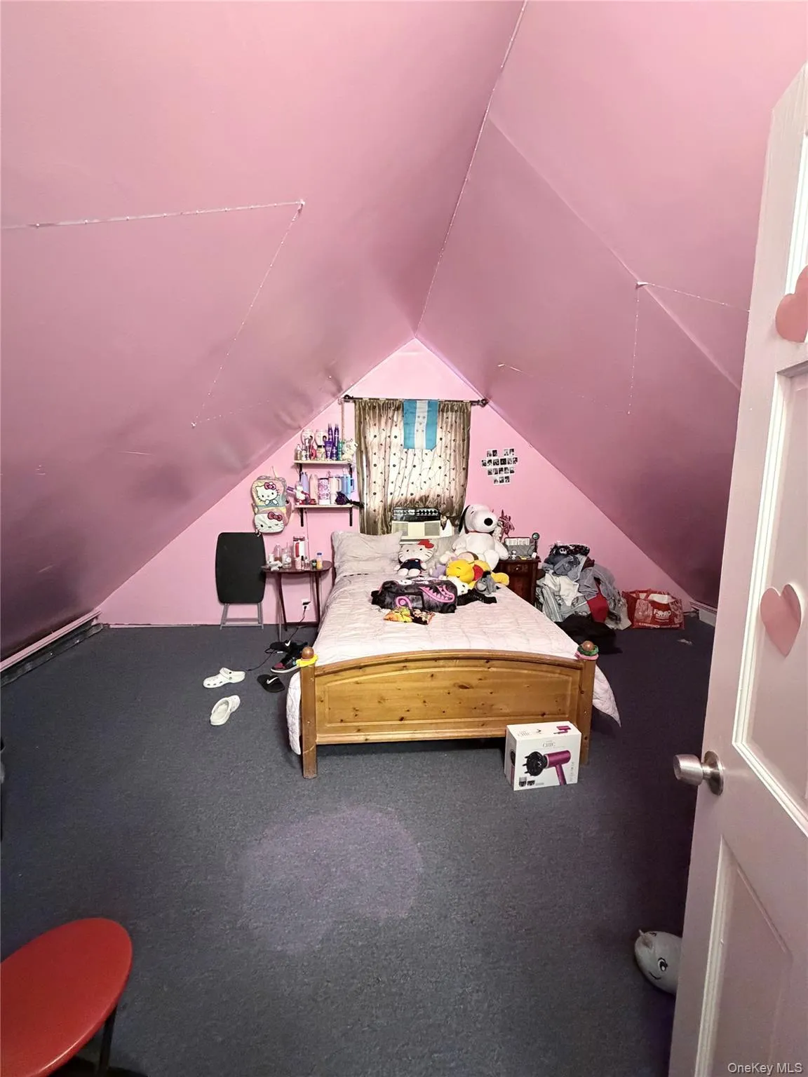 2nd. floor bedroom featuring sloped ceilings, a window with curtains, and dark carpeting 2nd. floor bedroom featuring sloped ceilings, a window with curtains, and dark carpeting