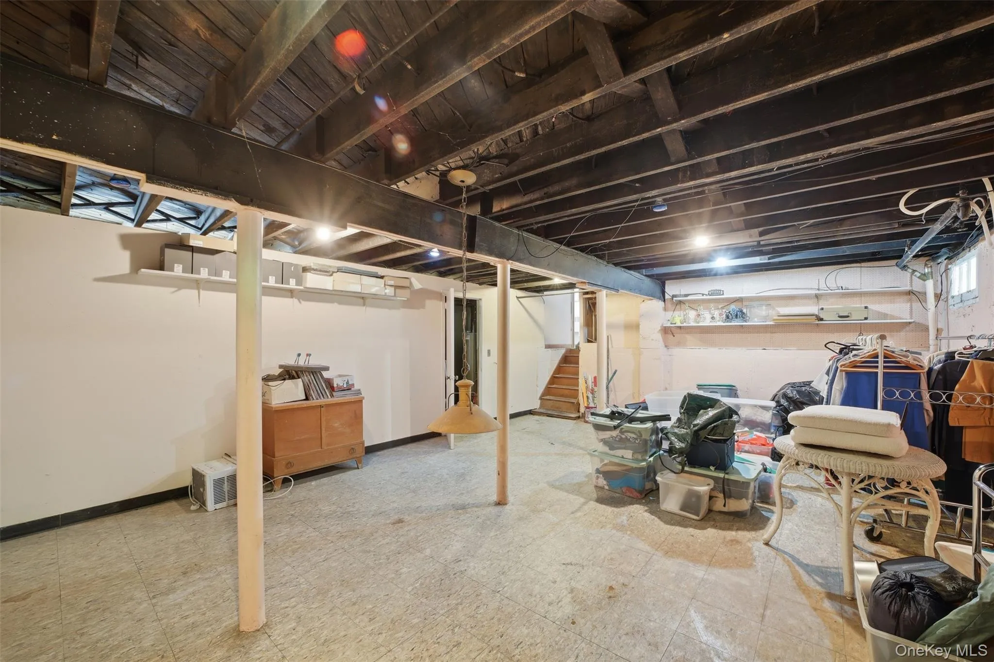 Spacious basement featuring exposed ceiling joists, support beams, and light-toned flooring Spacious basement featuring exposed ceiling joists, support beams, and light-toned flooring