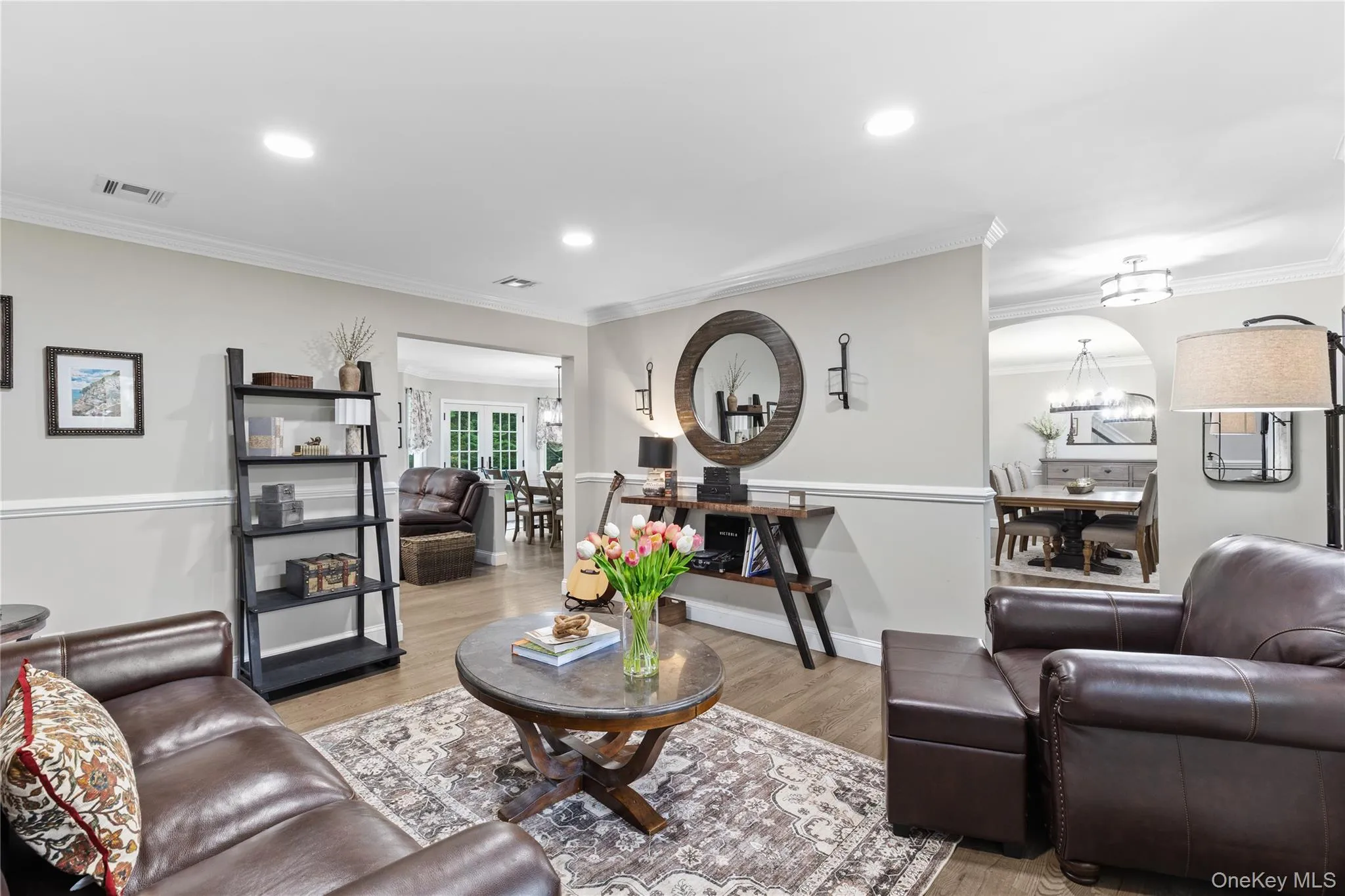 Living area featuring wood-finish flooring, recessed lighting, and crown molding Living area featuring wood-finish flooring, recessed lighting, and crown molding