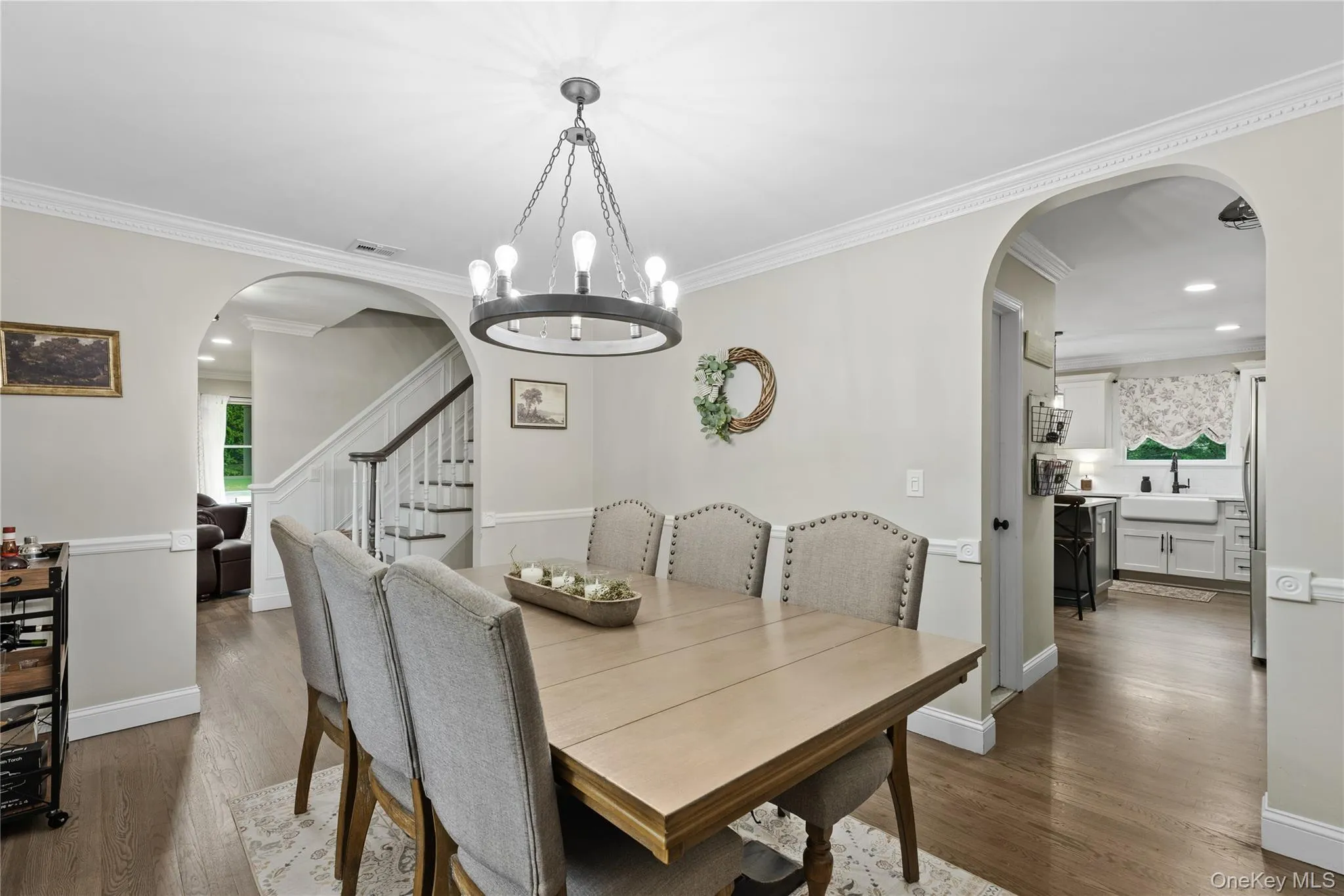 Dining area featuring a contemporary chandelier, crown molding, and wood-finish flooring Dining area featuring a contemporary chandelier, crown molding, and wood-finish flooring