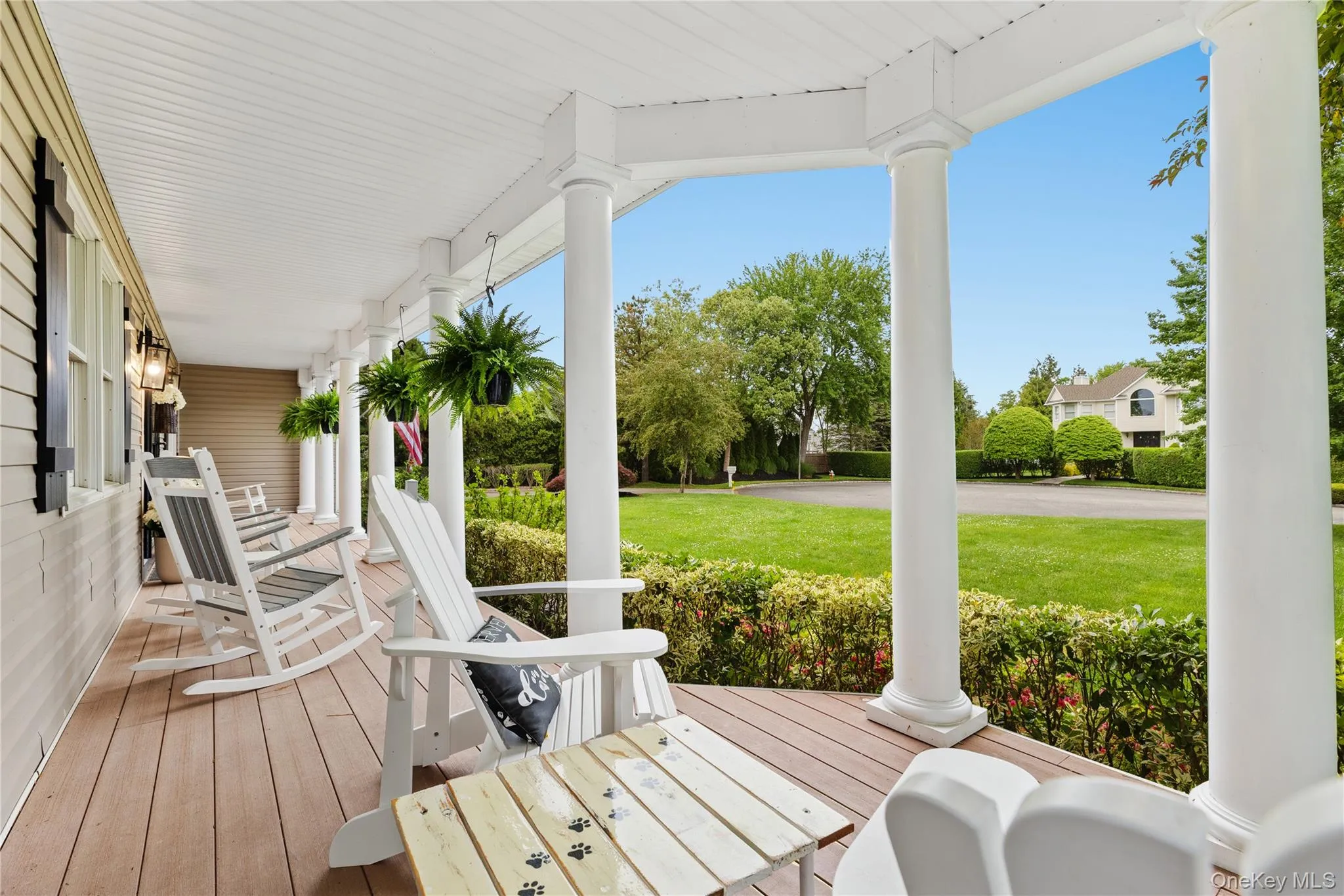 Spacious front porch featuring composite decking and white architectural columns Spacious front porch featuring composite decking and white architectural columns