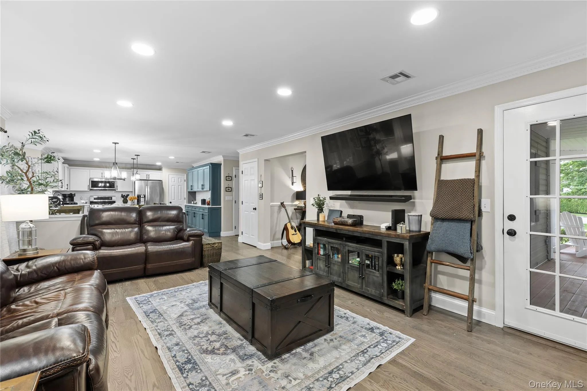 Living area featuring wood-finish flooring, recessed lighting, and crown molding Living area featuring wood-finish flooring, recessed lighting, and crown molding