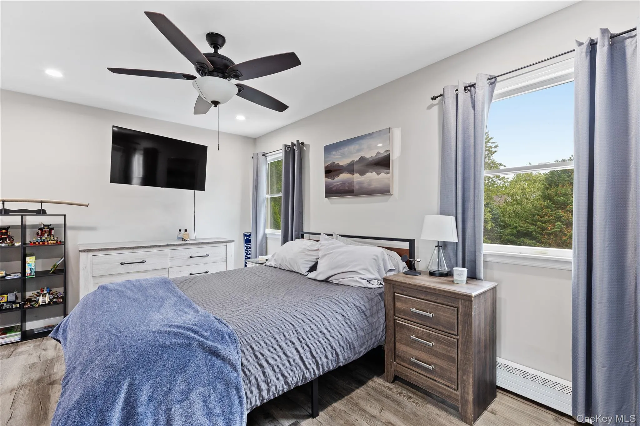 Room featuring wood-finish flooring, recessed lighting, and a ceiling fan with integrated light fixture Room featuring wood-finish flooring, recessed lighting, and a ceiling fan with integrated light fixture