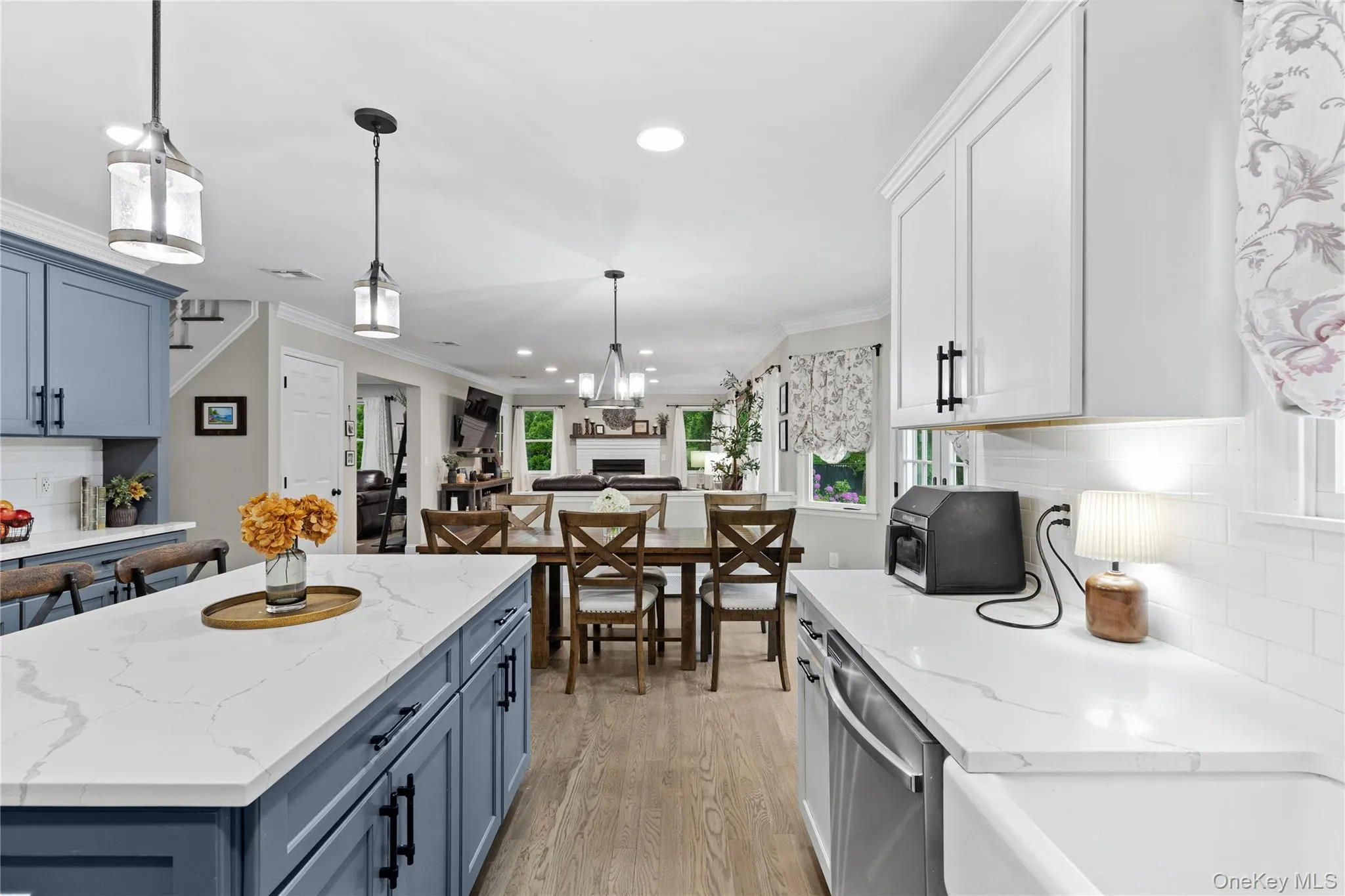 Open-concept kitchen featuring an oversized island with white quartz countertops and blue cabinetry Open-concept kitchen featuring an oversized island with white quartz countertops and blue cabinetry