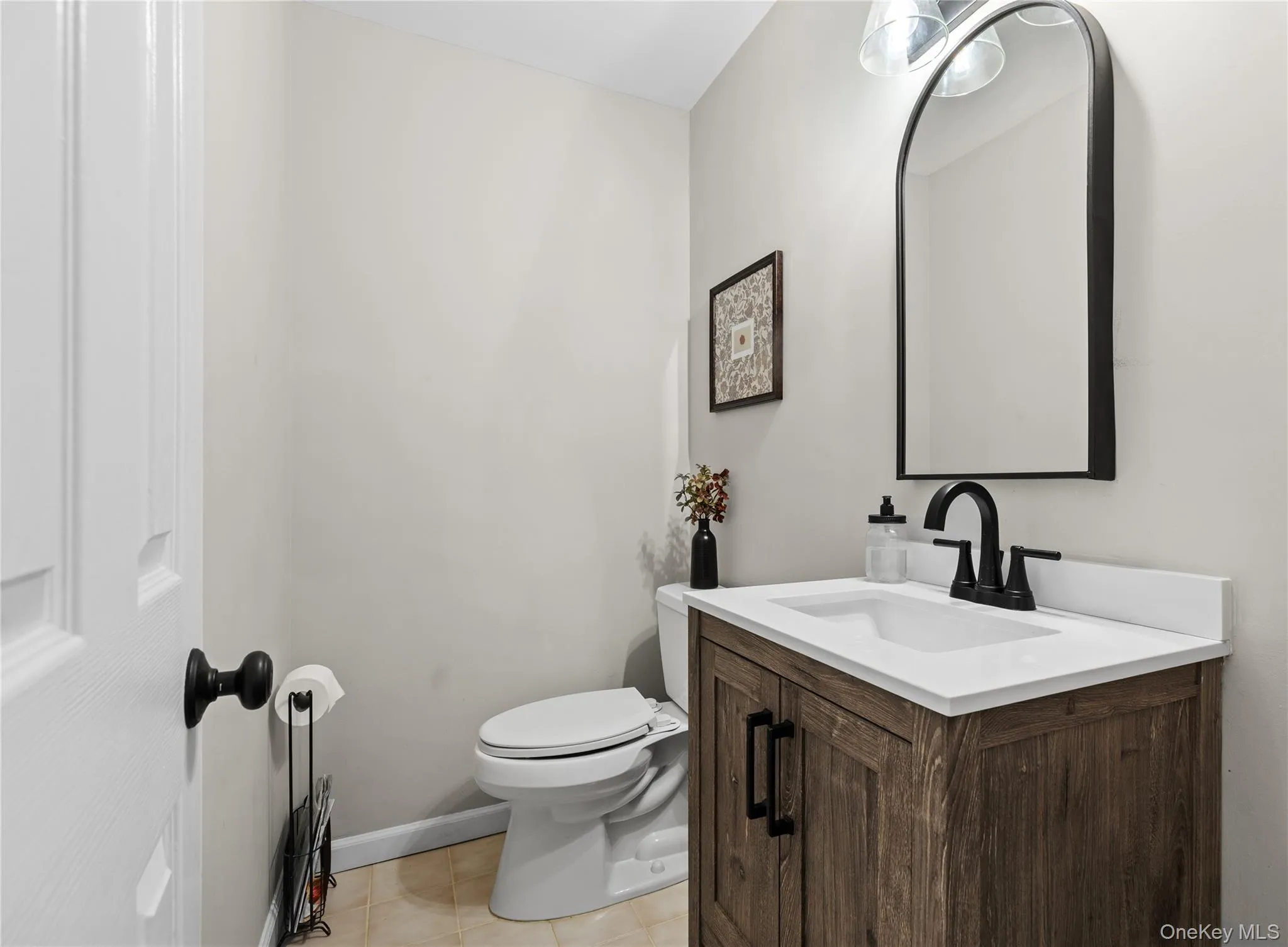 Powder room featuring a wood-finish vanity with a white countertop and undermount sink Powder room featuring a wood-finish vanity with a white countertop and undermount sink
