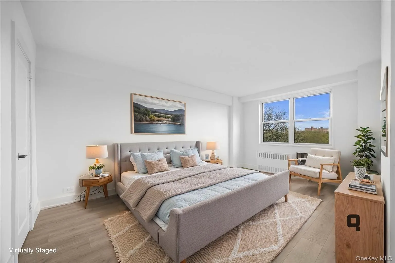 Bright bedroom featuring light vinyl flooring, white walls, and a large window Bright bedroom featuring light vinyl flooring, white walls, and a large window