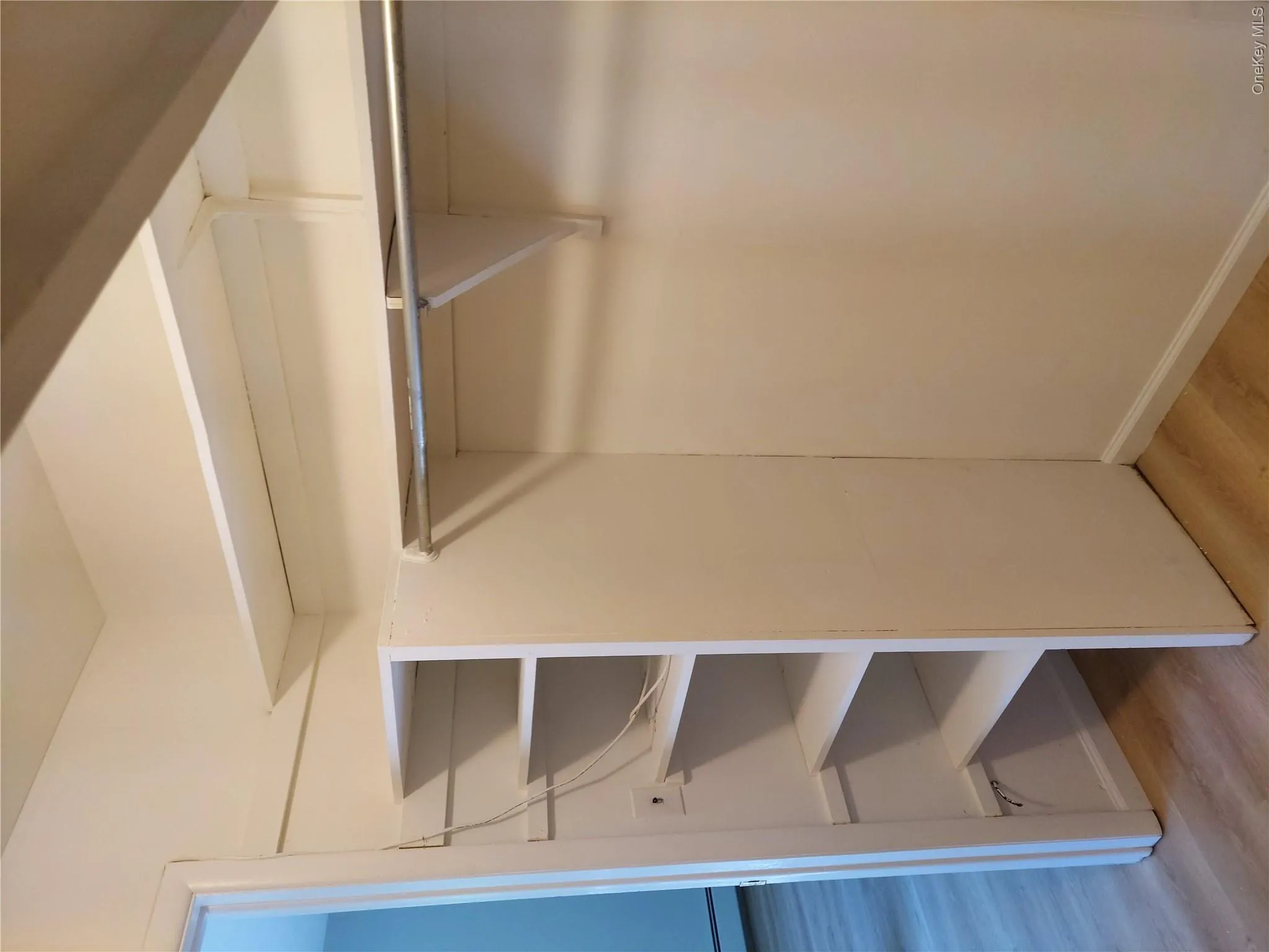Walk-in closet featuring extensive shelving and hanging rod storage with metal brackets and supports Walk-in closet featuring extensive shelving and hanging rod storage with metal brackets and supports