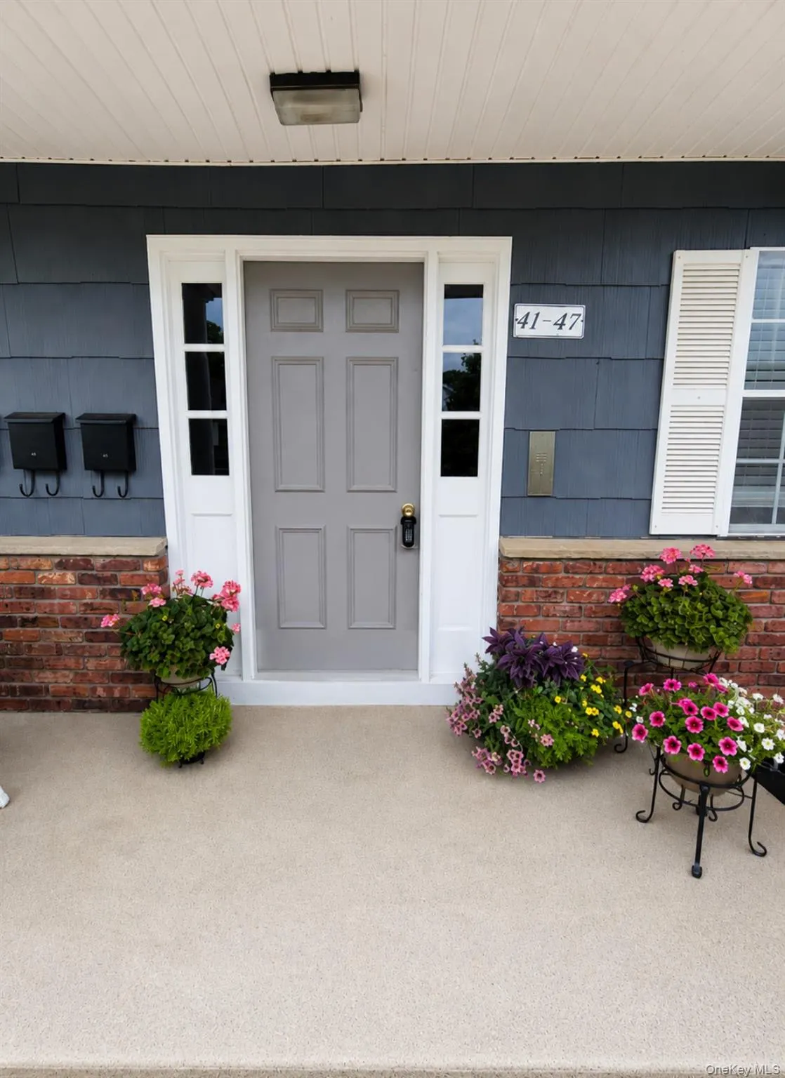 Front entrance featuring a gray paneled door with white trim and transom windows Front entrance featuring a gray paneled door with white trim and transom windows