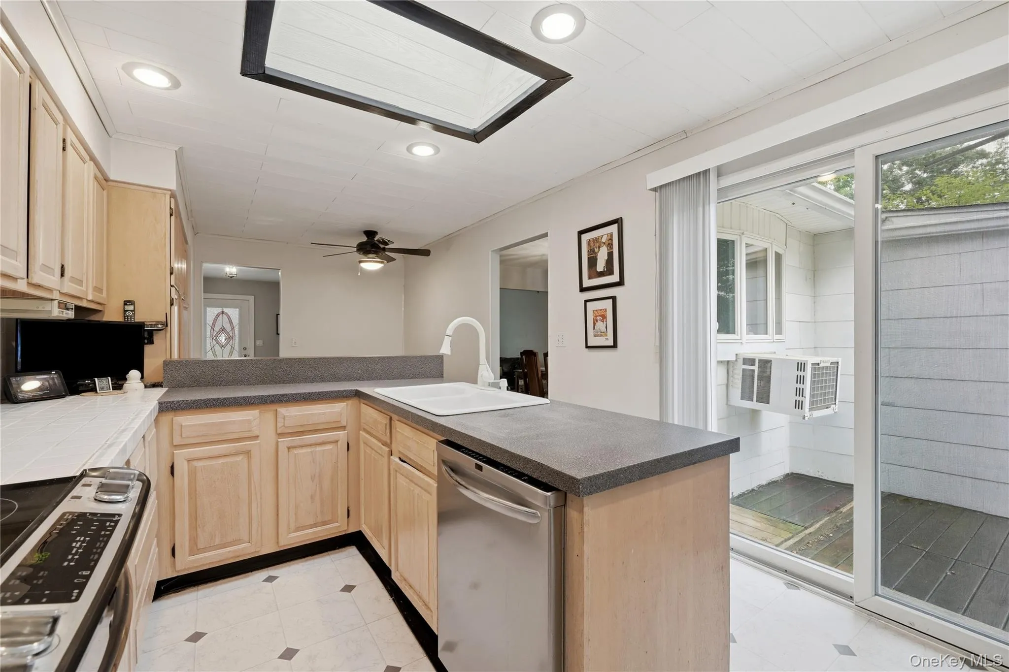 Kitchen Showcasing Skylight over Sink and view of Deck to Backyard Kitchen Showcasing Skylight over Sink and view of Deck to Backyard