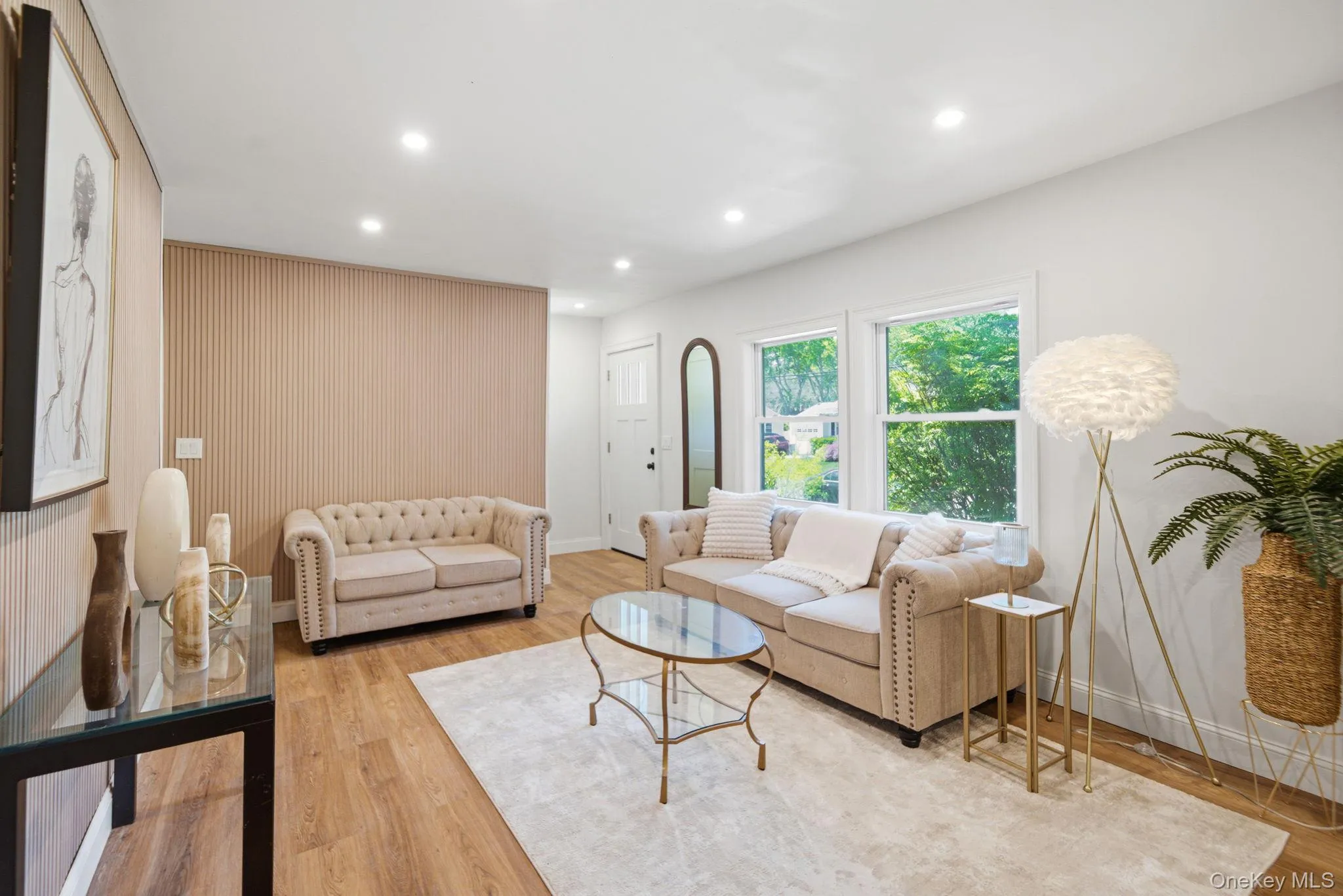 Spacious living area featuring light wood-finish flooring, recessed lighting, and white walls Spacious living area featuring light wood-finish flooring, recessed lighting, and white walls