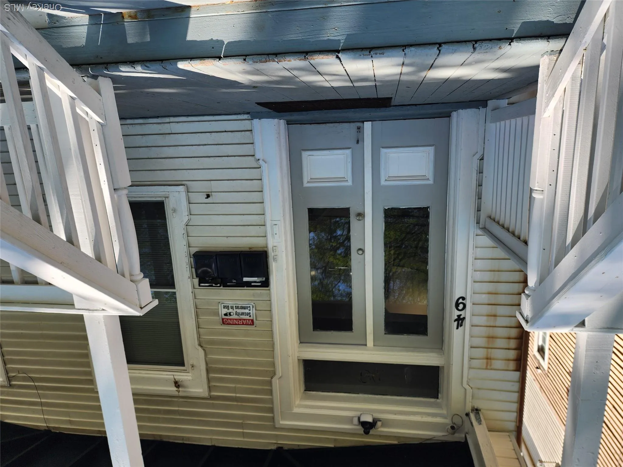 Front entry featuring a double glass-panel door, transom window, and adjacent window Front entry featuring a double glass-panel door, transom window, and adjacent window