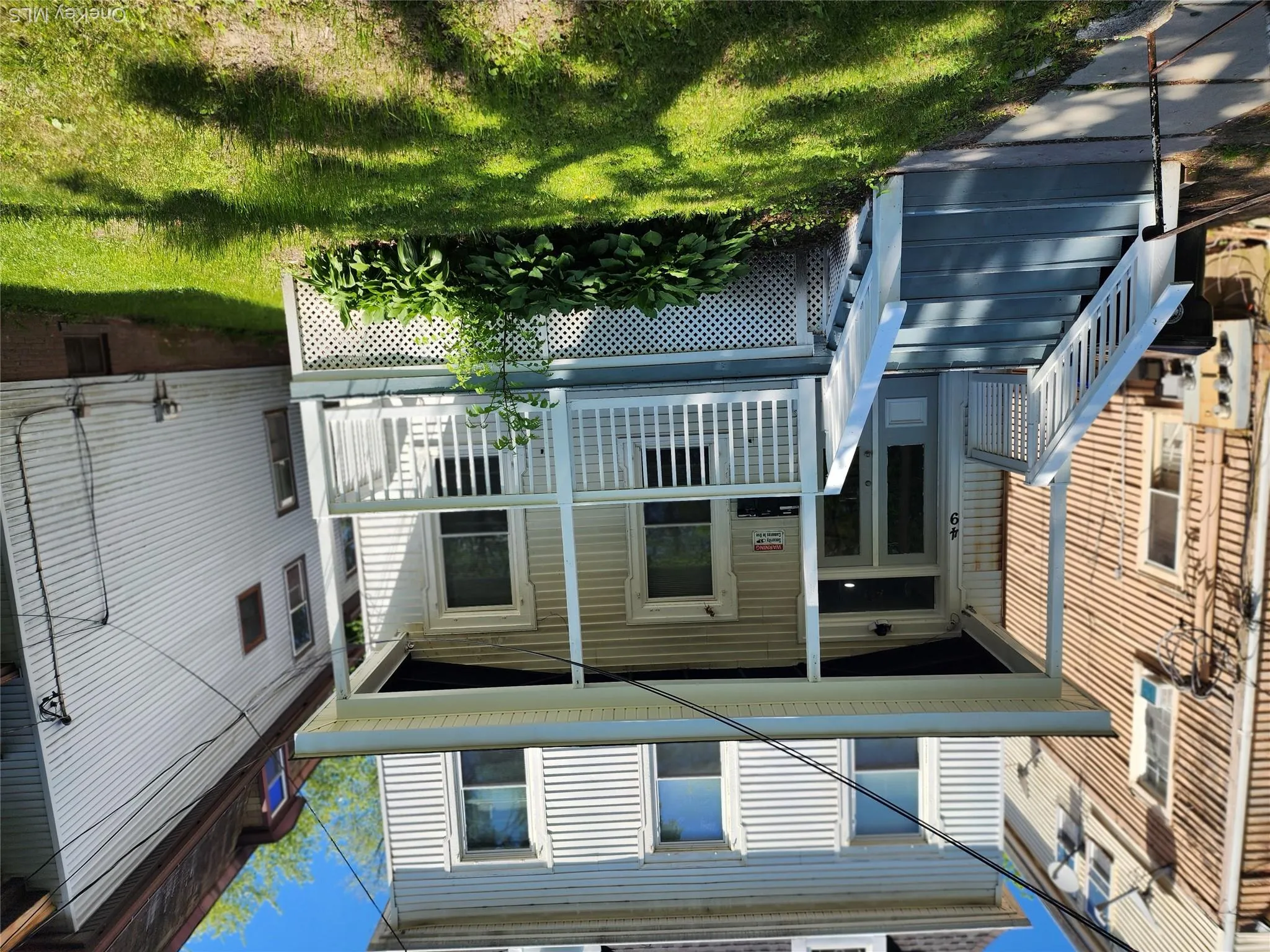 Two-story residence featuring white siding and a covered front porch with white railings Two-story residence featuring white siding and a covered front porch with white railings