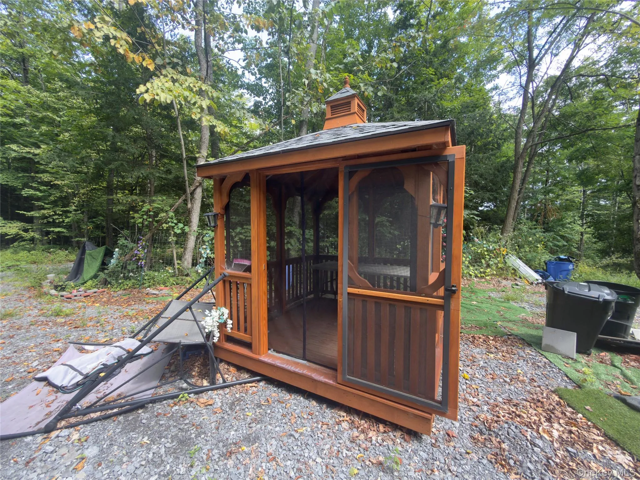 Wood-finish screened gazebo with a cupola feature Wood-finish screened gazebo with a cupola feature