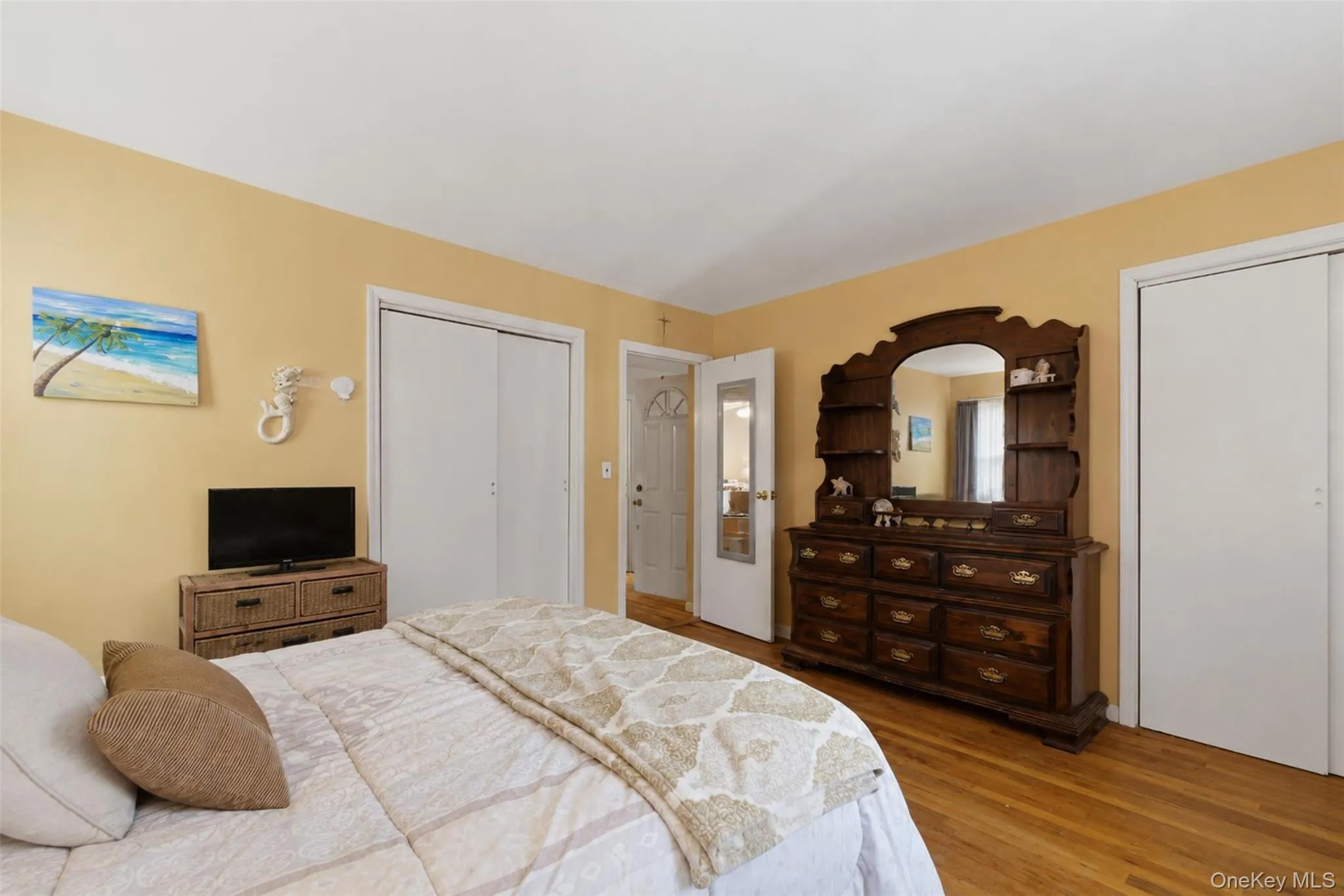 Warmly toned walls frame a bedroom featuring wood-finish flooring Warmly toned walls frame a bedroom featuring wood-finish flooring