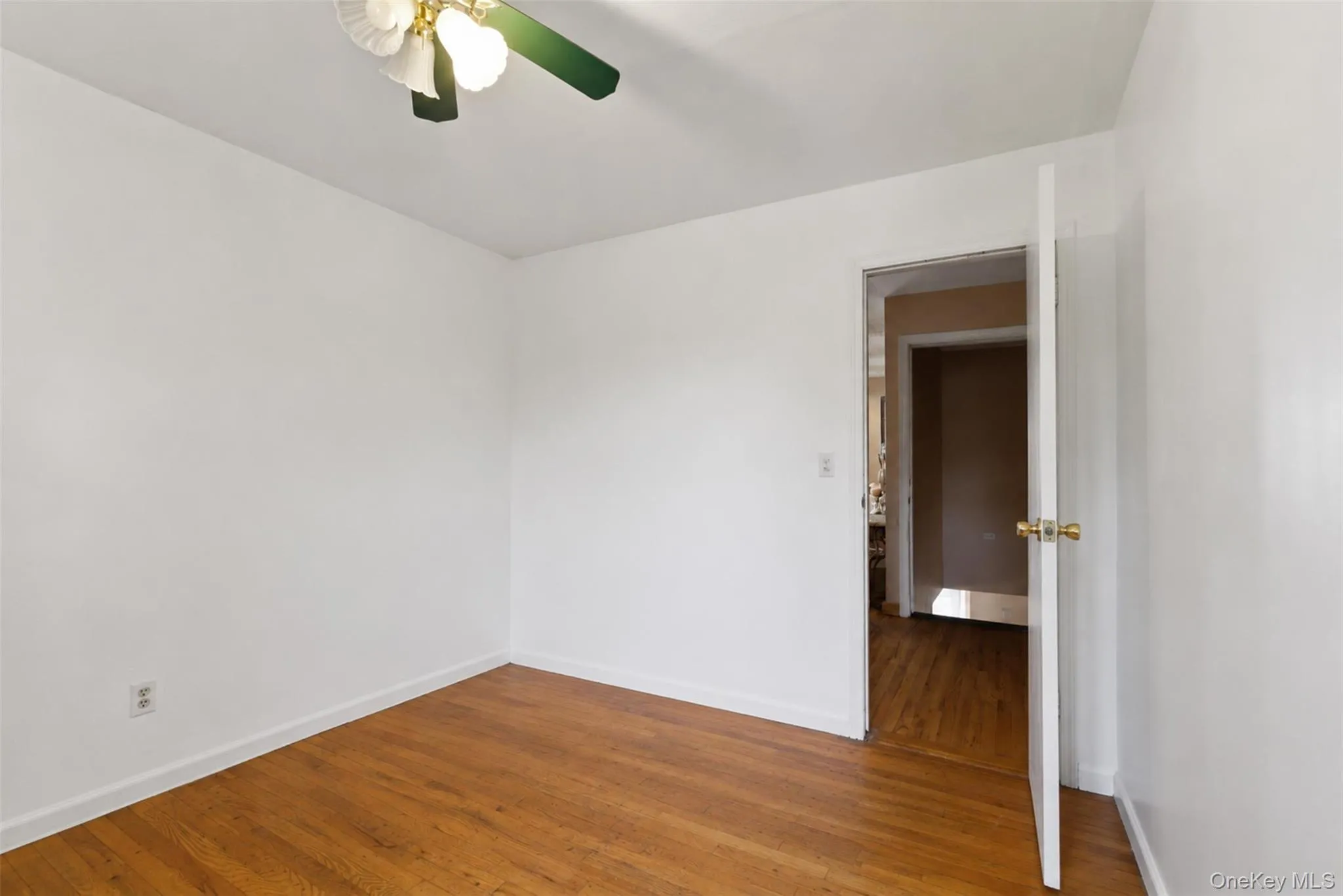 Interior room featuring hardwood flooring and a ceiling fan Interior room featuring hardwood flooring and a ceiling fan