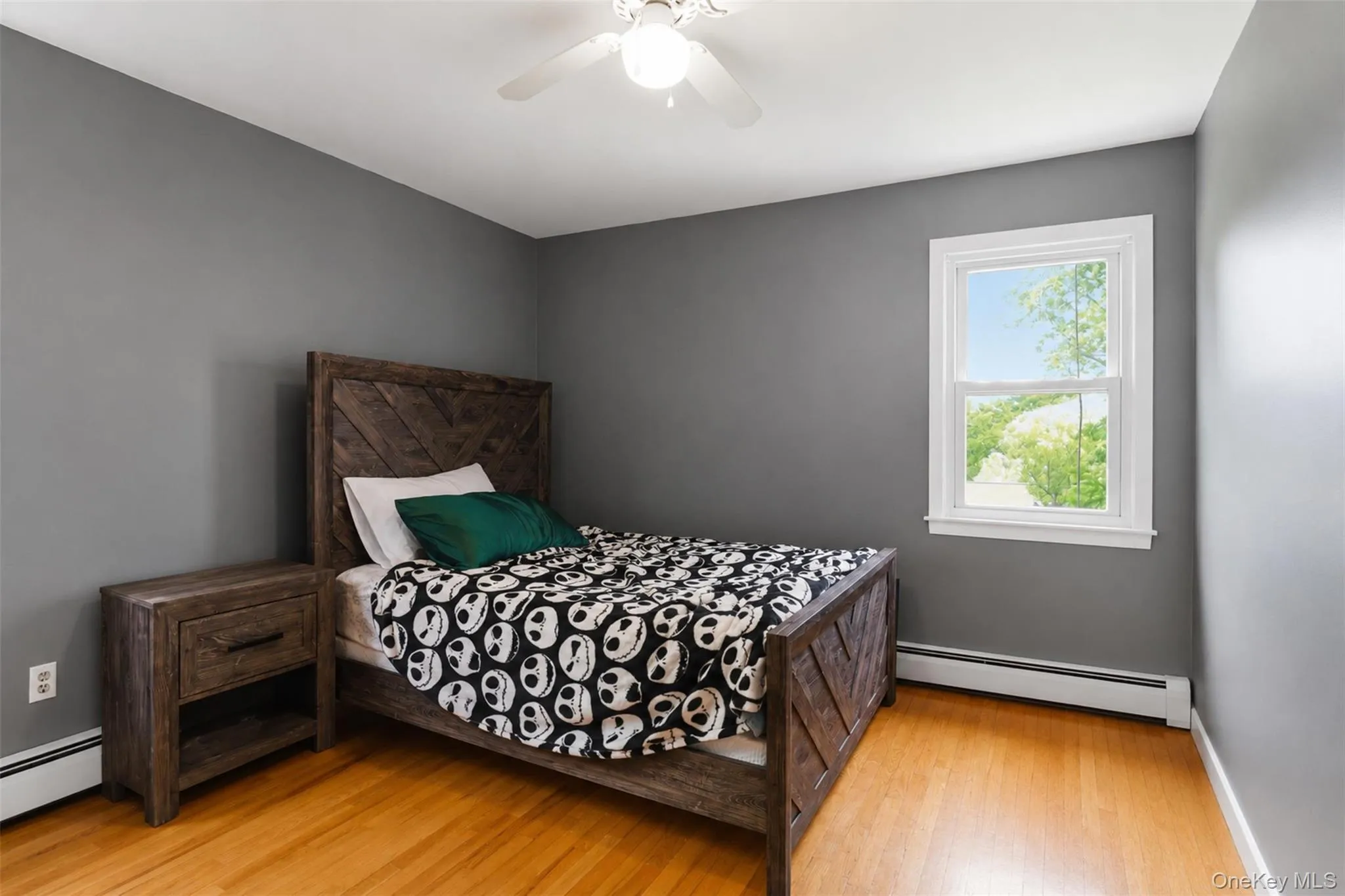 Bedroom with hardwood flooring and a single window Bedroom with hardwood flooring and a single window