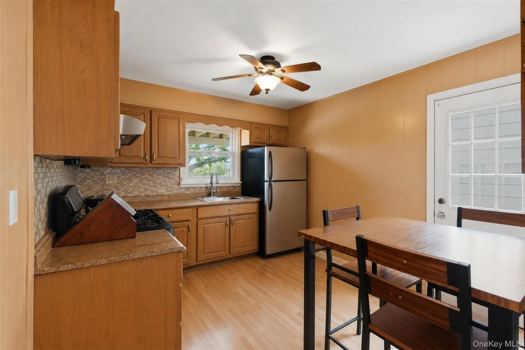 Efficient kitchen with wood-finish cabinetry and light-toned countertops Efficient kitchen with wood-finish cabinetry and light-toned countertops