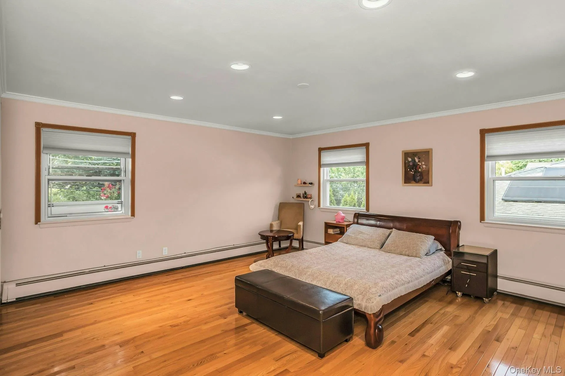 Primary Bedroom featuring crown molding, wood flooring, and recessed lighting Primary Bedroom featuring crown molding, wood flooring, and recessed lighting