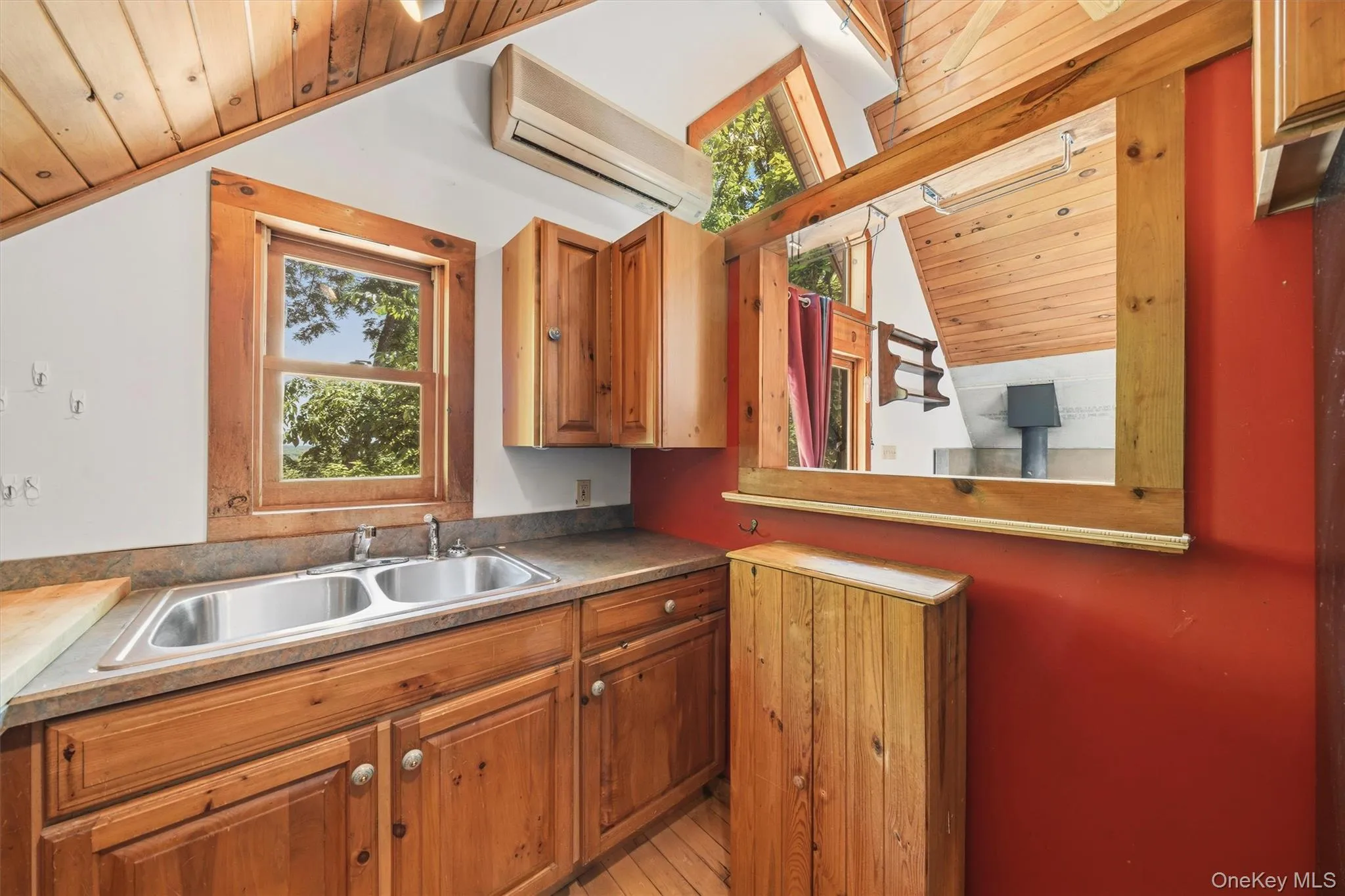 Kitchenette featuring wood-finish cabinetry, a double basin stainless steel sink, and a laminate countertop Kitchenette featuring wood-finish cabinetry, a double basin stainless steel sink, and a laminate countertop