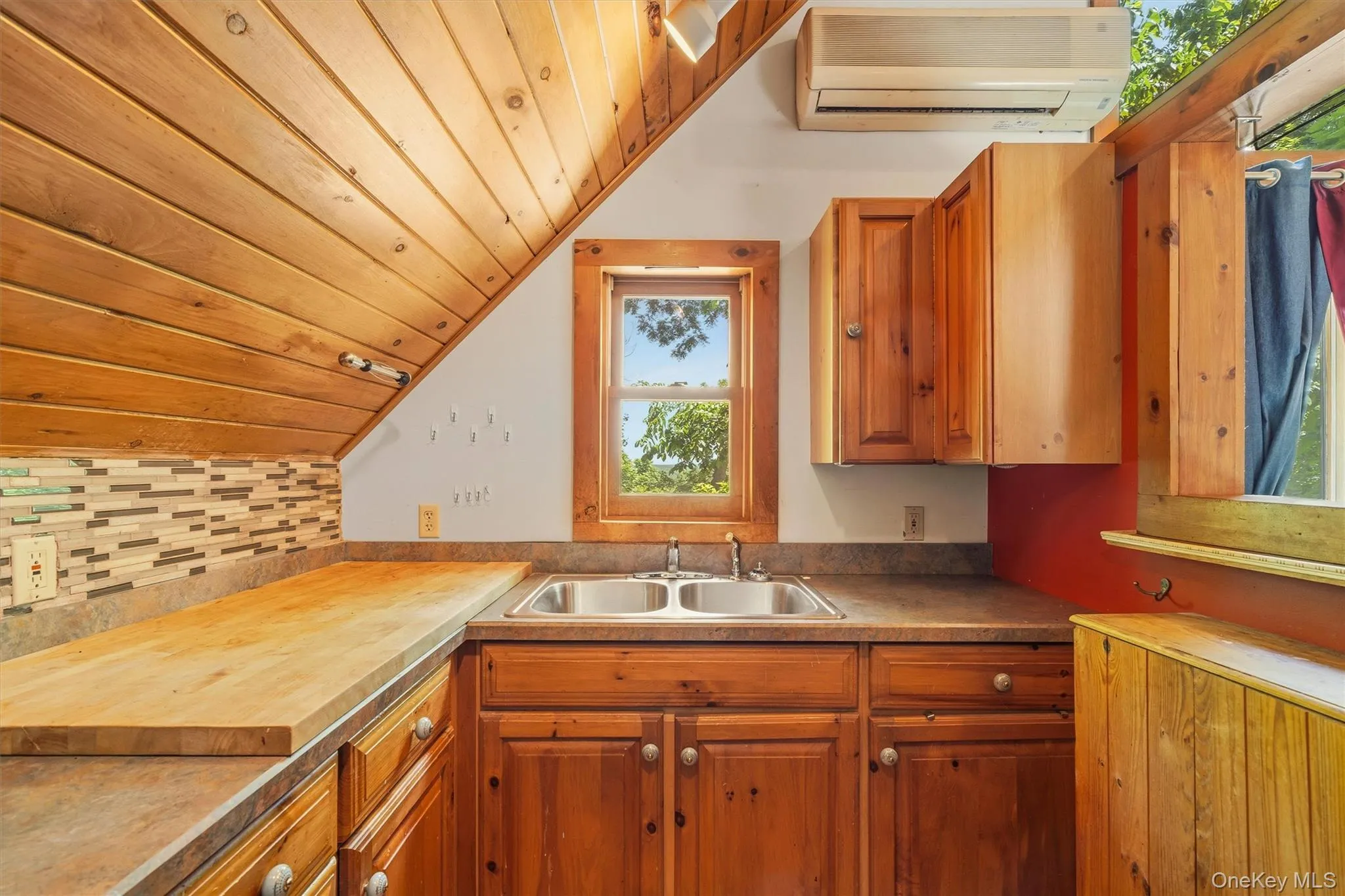 Kitchenette featuring wood cabinetry, butcher block countertop, and dual basin stainless steel sink Kitchenette featuring wood cabinetry, butcher block countertop, and dual basin stainless steel sink