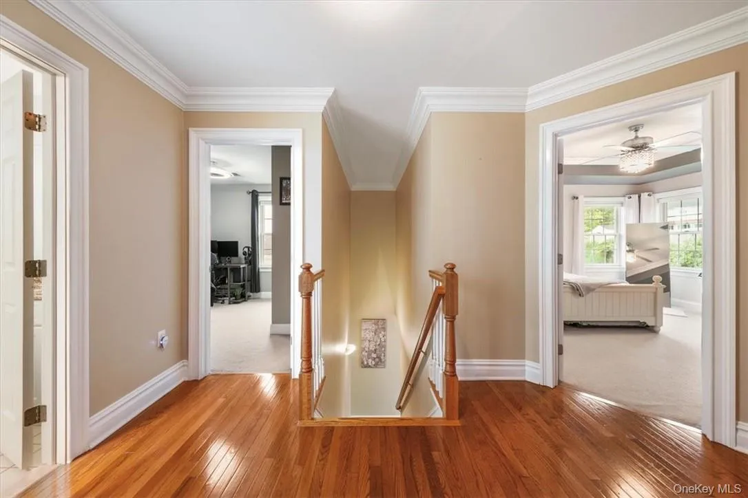 Hallway with ornamental molding and hardwood / wood-style floors Hallway with ornamental molding and hardwood / wood-style floors