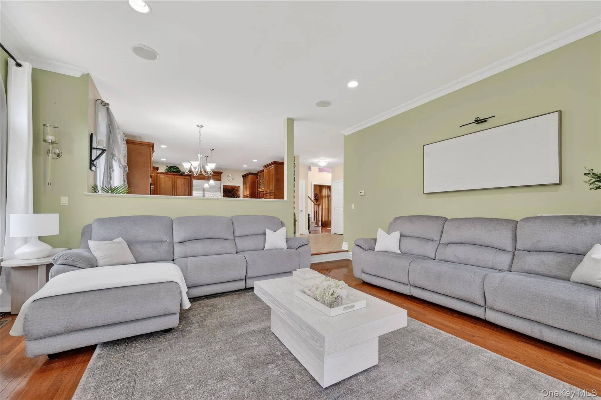 Spacious living area featuring hardwood flooring and recessed lighting Spacious living area featuring hardwood flooring and recessed lighting