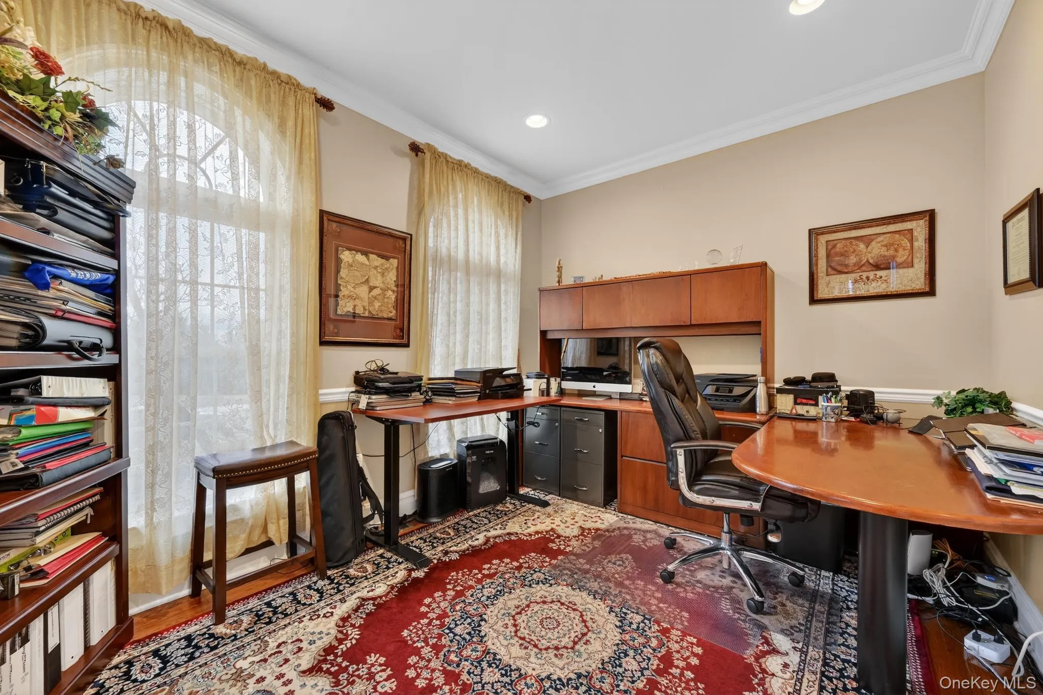 Room featuring arched windows with mullions, crown molding, recessed lighting, and wood-finish flooring Room featuring arched windows with mullions, crown molding, recessed lighting, and wood-finish flooring