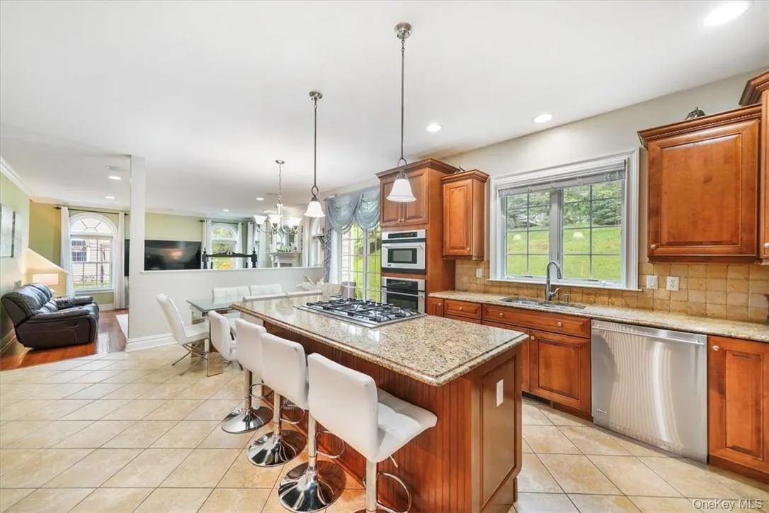 Kitchen with stainless steel appliances, sink, a center island, and backsplash Kitchen with stainless steel appliances, sink, a center island, and backsplash