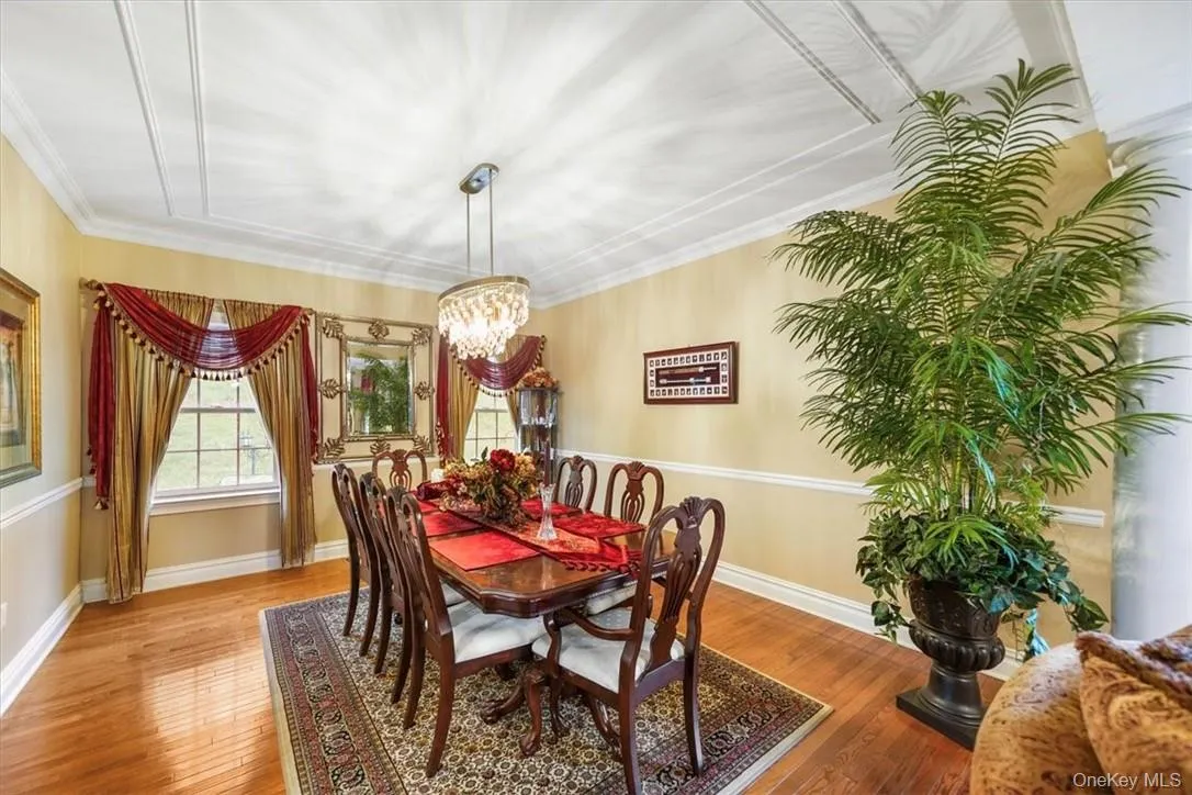 Dining space with ornamental molding, an inviting chandelier, and hardwood / wood-style floors Dining space with ornamental molding, an inviting chandelier, and hardwood / wood-style floors