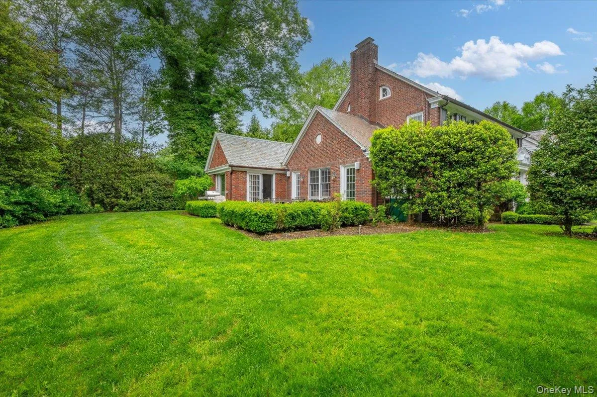 View of the level and professionally landscaped 0.3 acre setting complete with a stone patio. View of the level and professionally landscaped 0.3 acre setting complete with a stone patio.