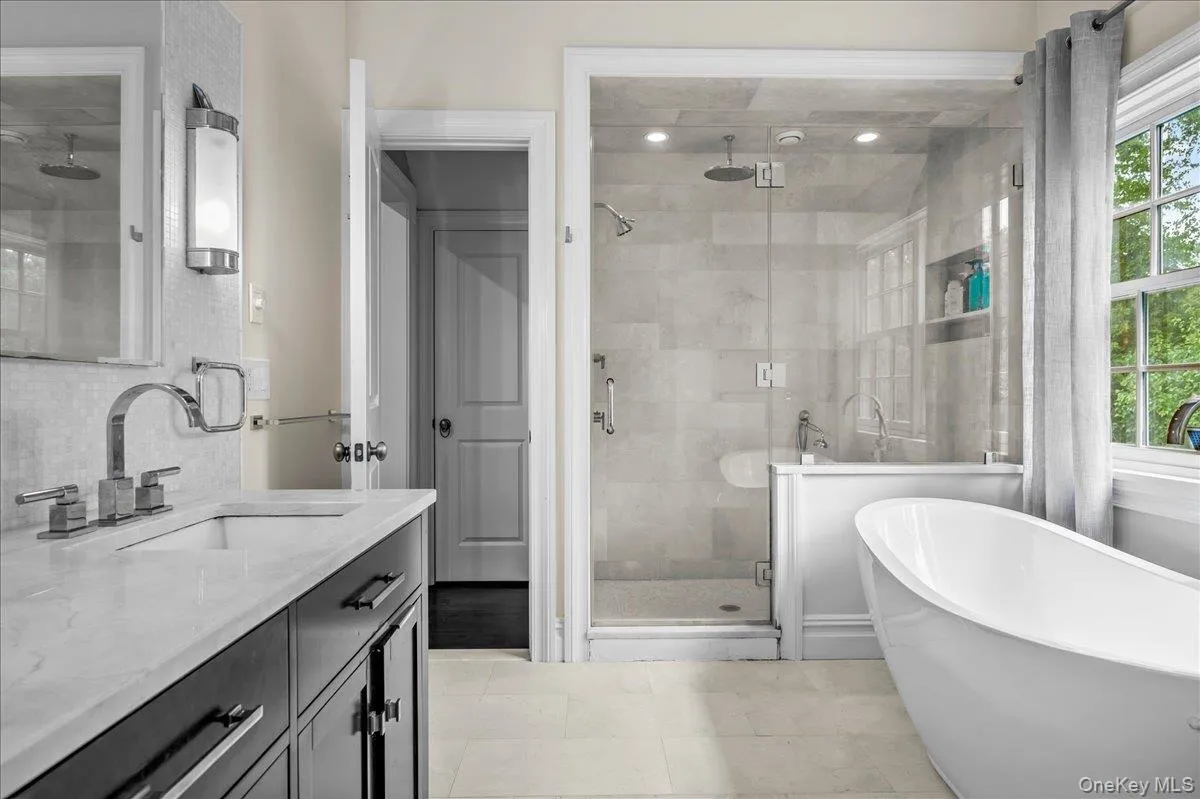 The spa-style primary bathroom features an oversized glass shower, separate soaking tub, and dual sinks. The spa-style primary bathroom features an oversized glass shower, separate soaking tub, and dual sinks.