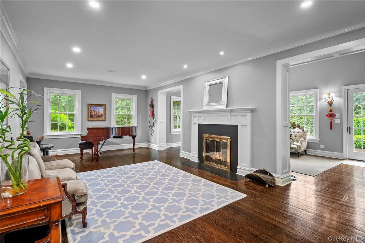 Formal living room with multiple exposures and fireplace opens to a stunning sunroom with large windows and glass door to the property. Formal living room with multiple exposures and fireplace opens to a stunning sunroom with large windows and glass door to the property.