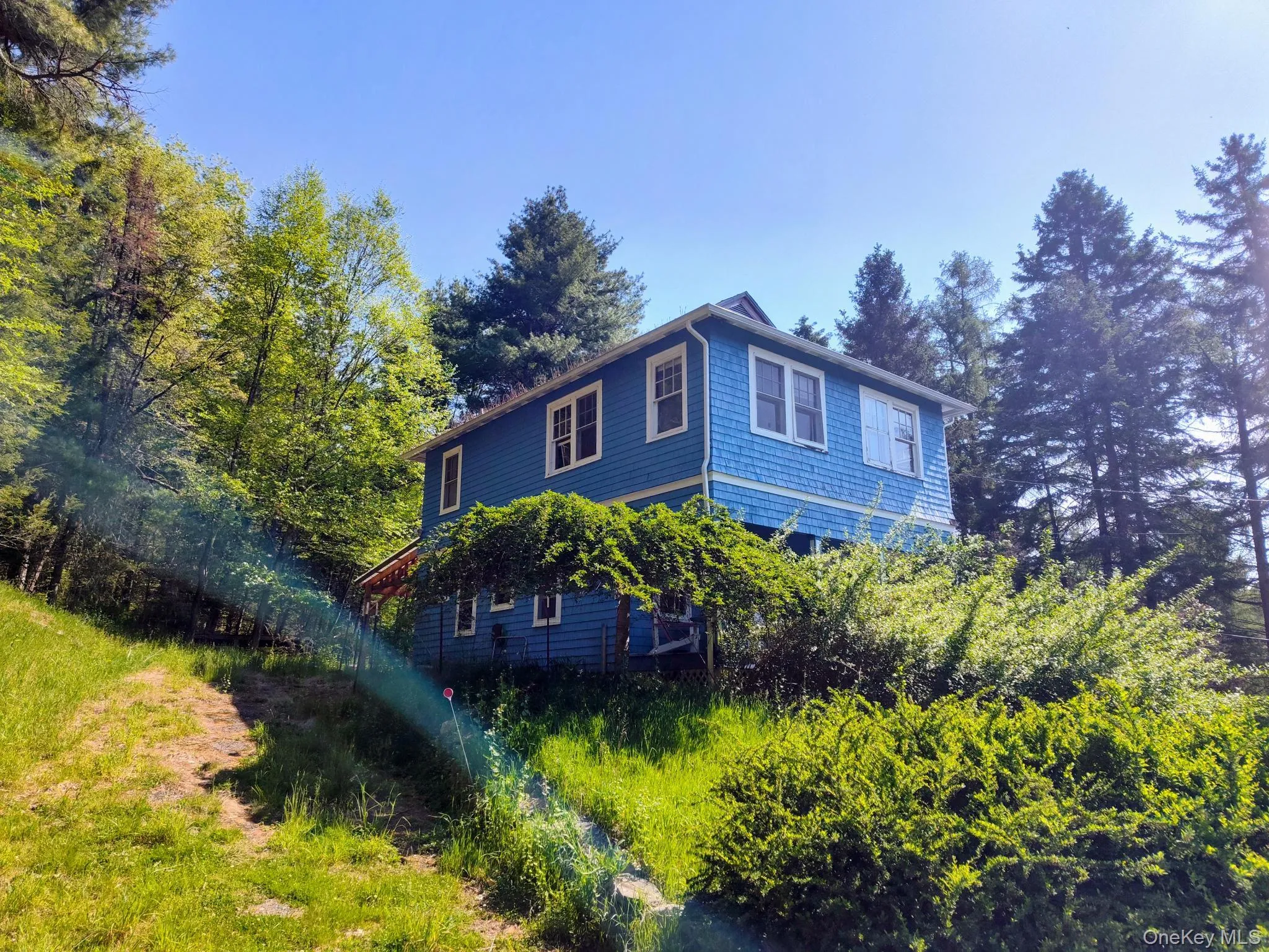 Two-story residence featuring blue shingle siding and white trim windows Two-story residence featuring blue shingle siding and white trim windows