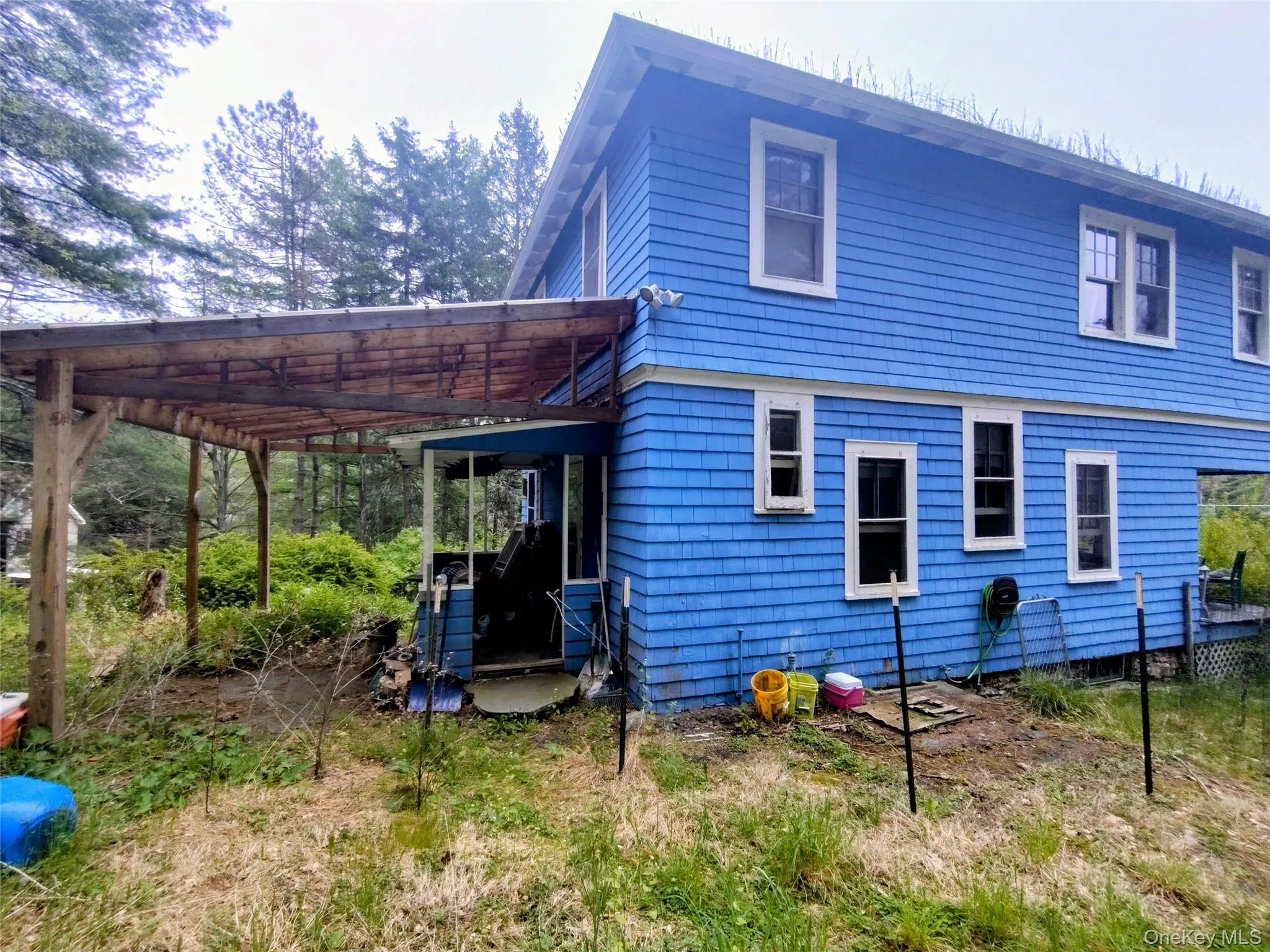 Blue shingle-sided exterior with white trim windows Blue shingle-sided exterior with white trim windows